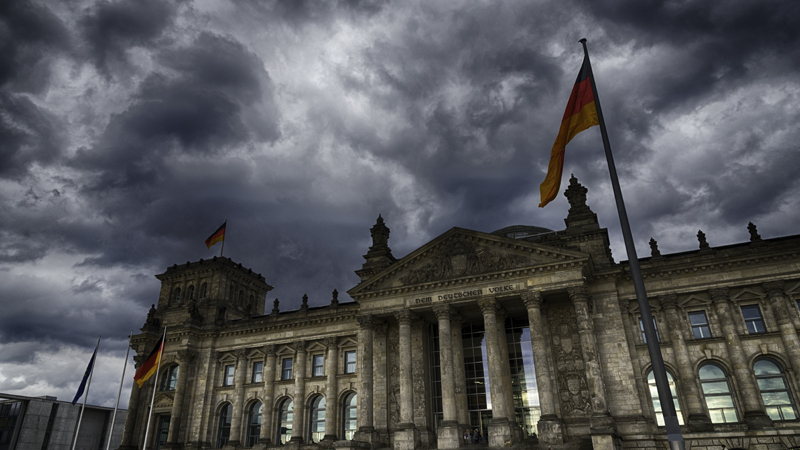 Der deutsche Bundestag in Berlin im Zwielicht vor dunklen Wolken