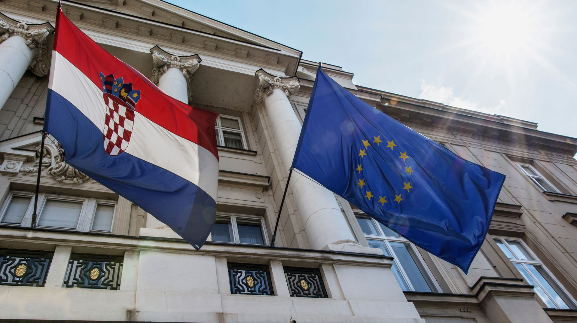 Das kroatische Parlament in Zagreb mit Flaggen Kroatiens und der Europäischen Union