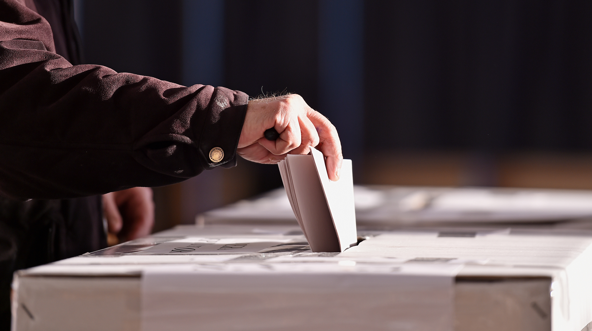 Hand beim Einwurf des Wahlzettels in die Wahlurne (Symbolfoto)