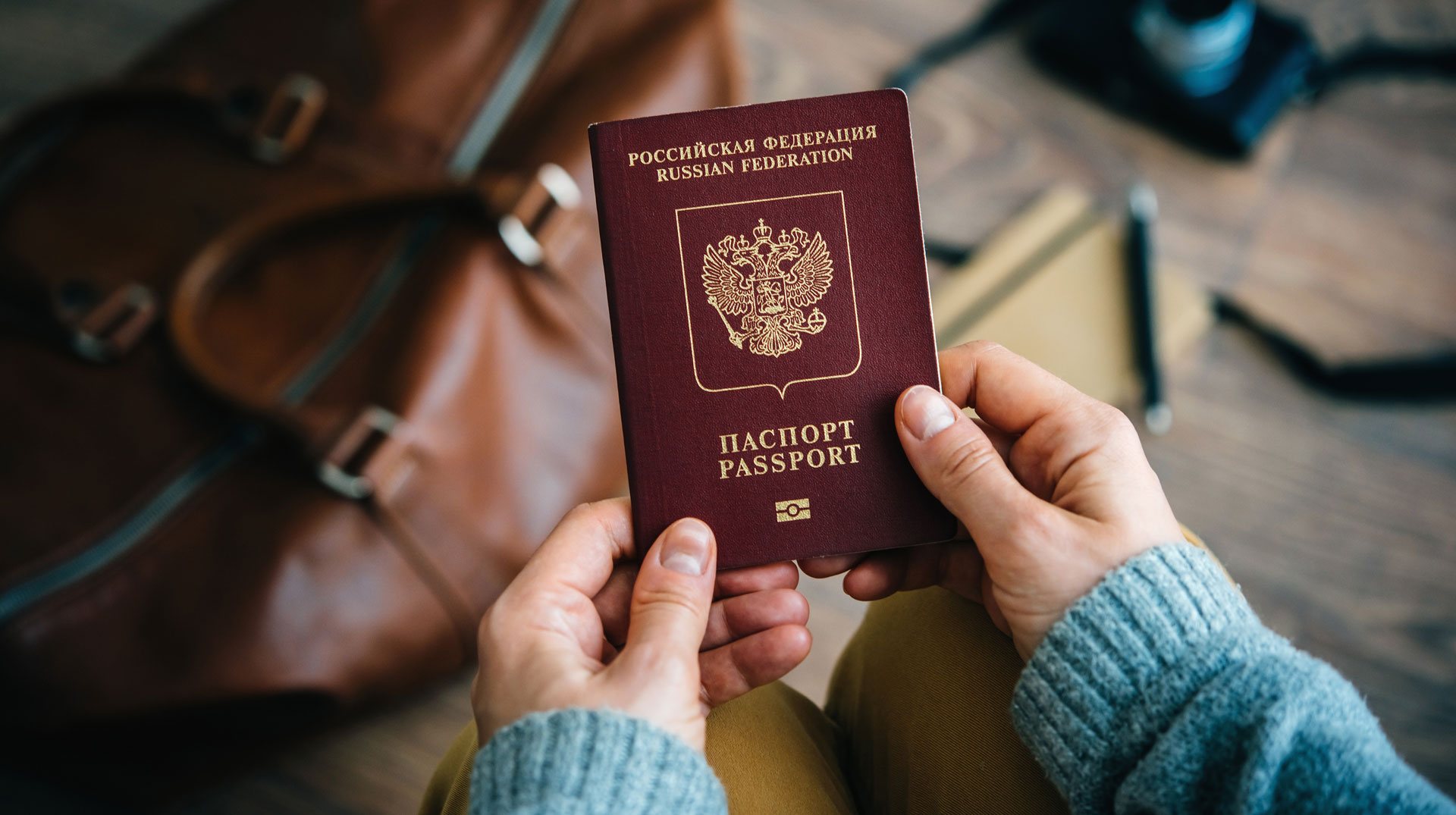 Russischer Pass und gepackte Koffer. Symbolbild Flucht aus Russland.
