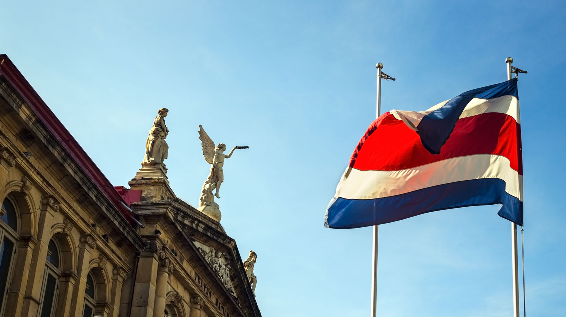 The flag of Costa Rica waving against the sun at the heart of San José