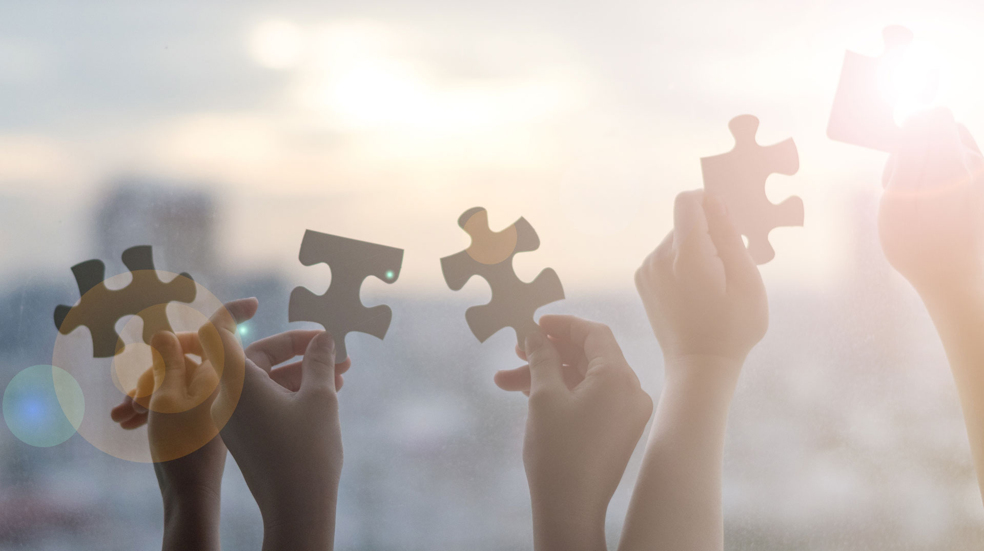 Hände halten Puzzleteile in die Luft