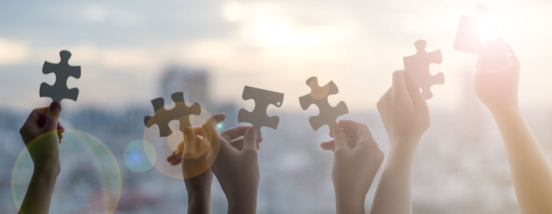 Hände halten Puzzleteile in die Luft