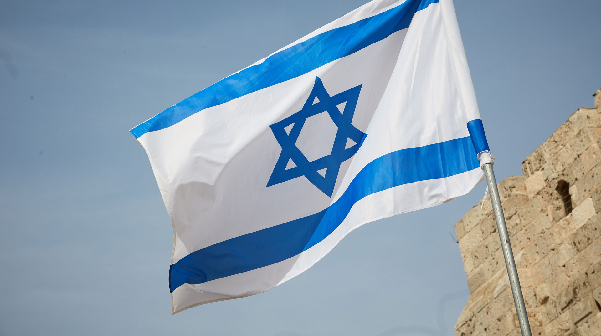 flag of Israel against the sky and the wall Fahne Israel