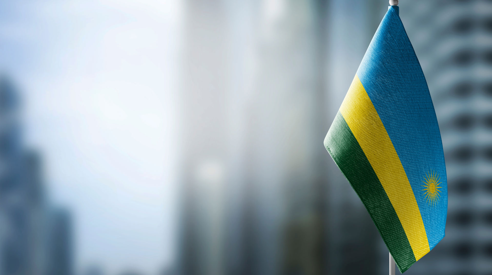 Flagge von Ruanda vor verschwommener Straßenszene
