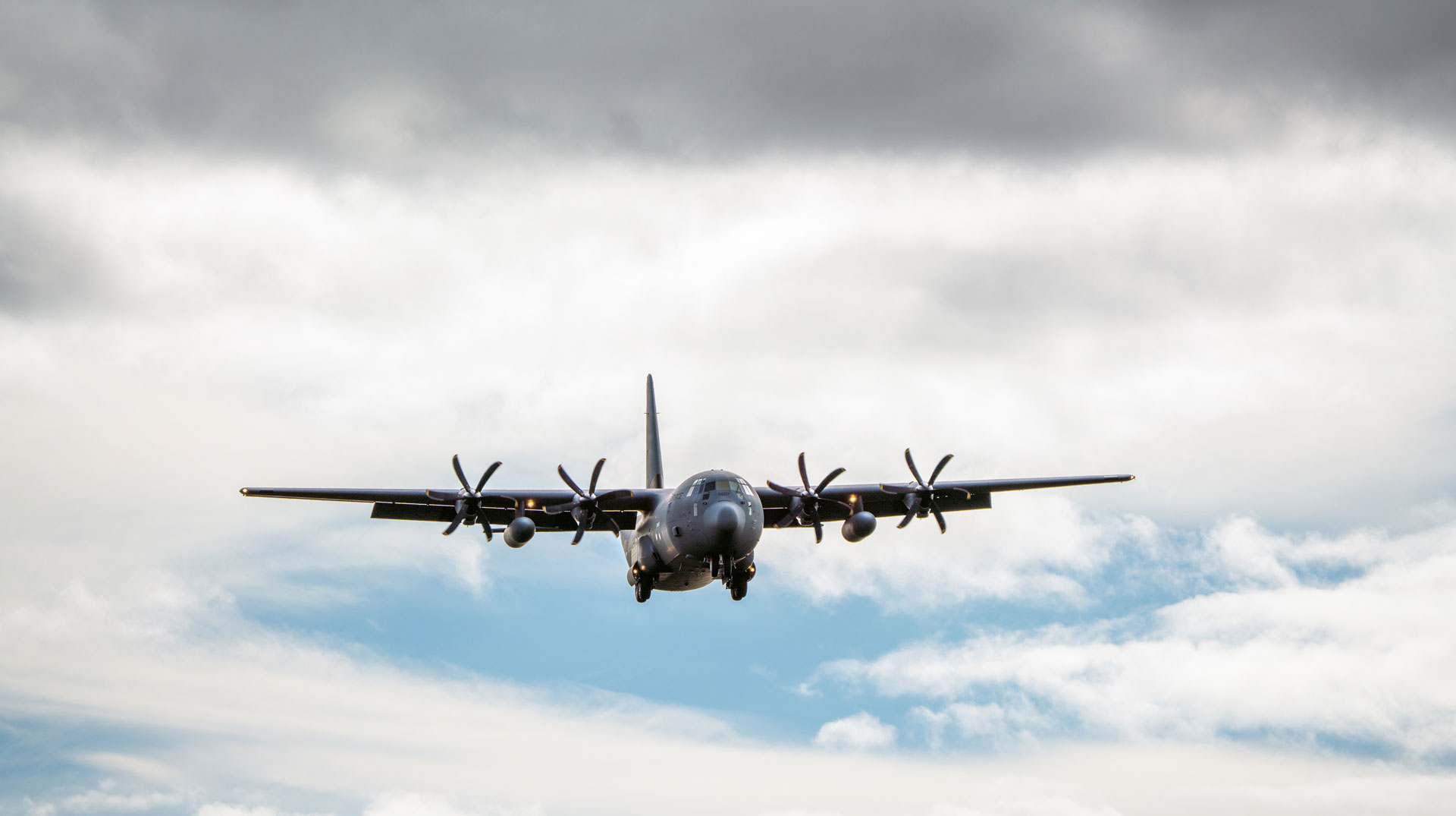 Militärflugzeug vor wolkigem Himmel