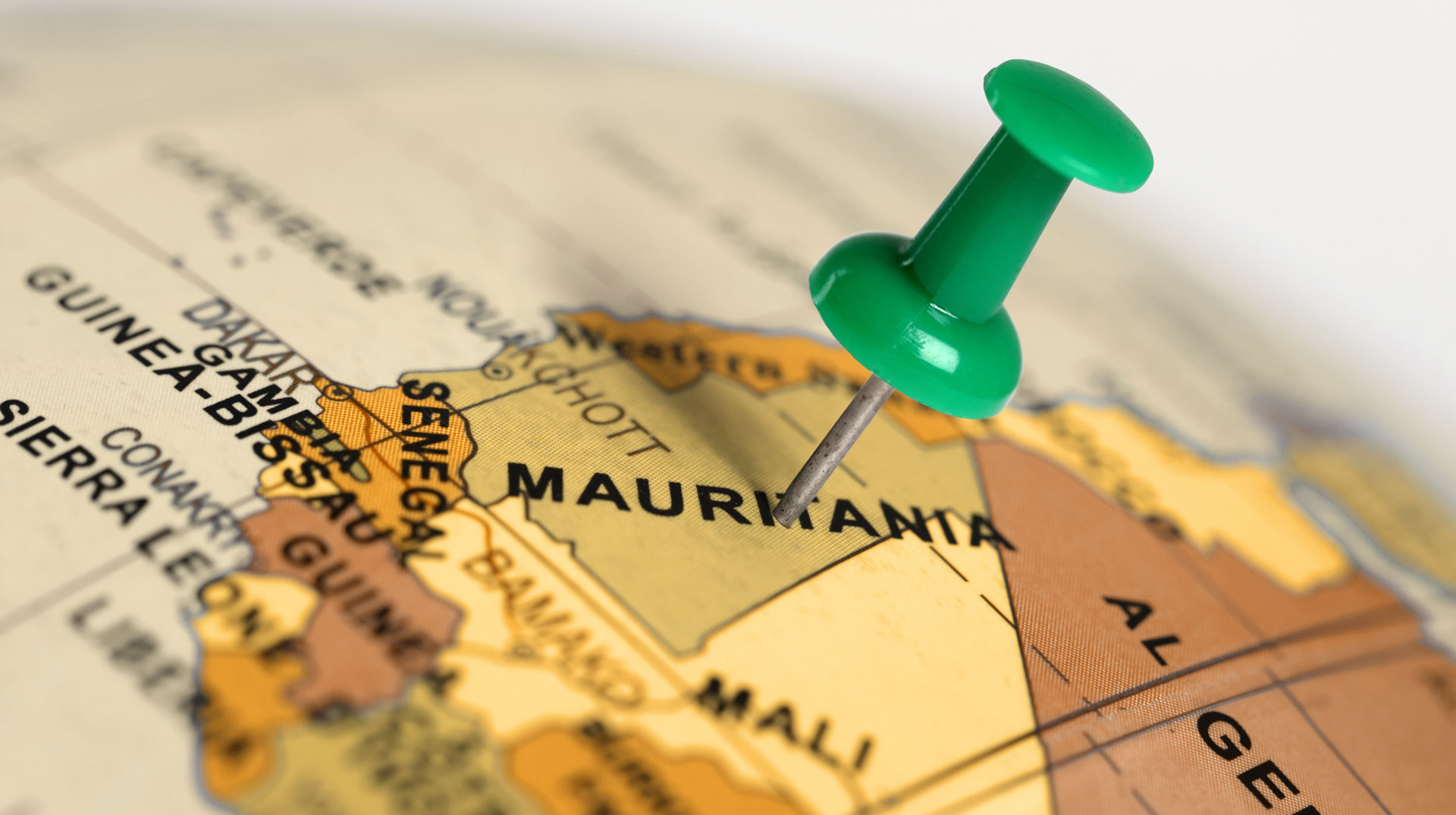 Symbolbild Mauretanien: Ein Pin auf der Landkarte zeigt Mauretanien auf einer Weltkarte. Schriftzug Nouakchott.