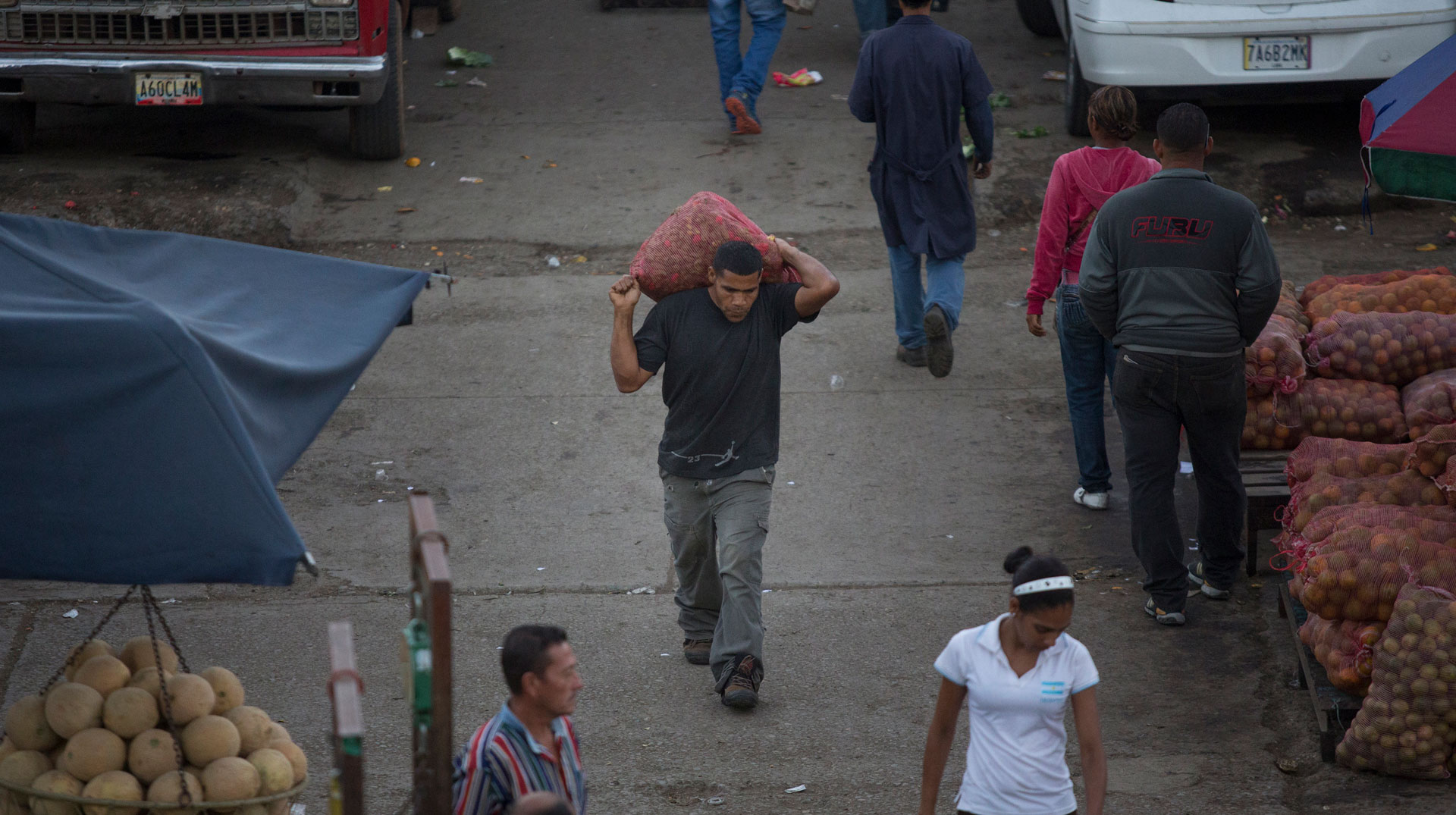 Ein Lastträger trägt einen Sack mit Chilischoten auf seinem Rücken, auf dem Großmarkt in Caracas