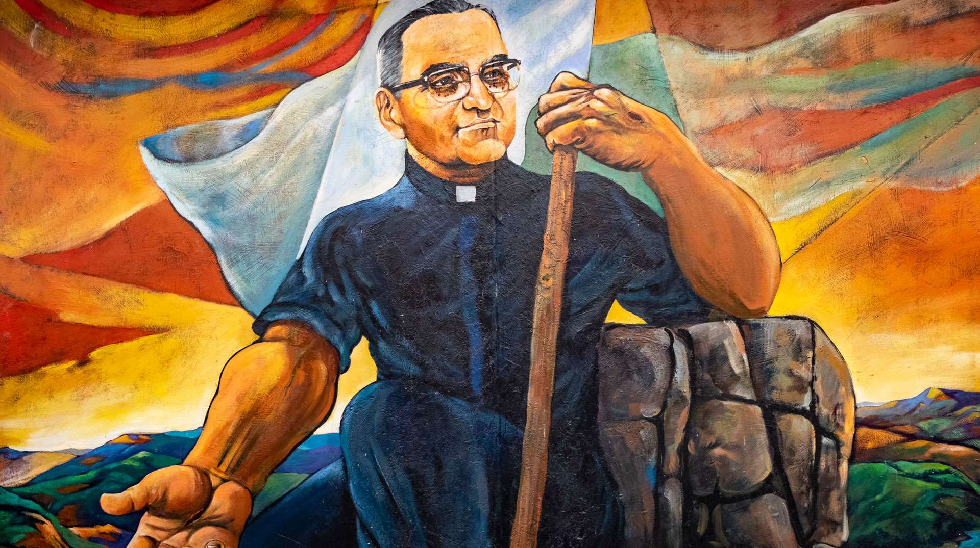 Gemaltes Bild von Óscar Romero mit römischem Kragen, weißer Flagge, Wundmalen an der linken Hand sowie der ausgestreckten rechten Hand.