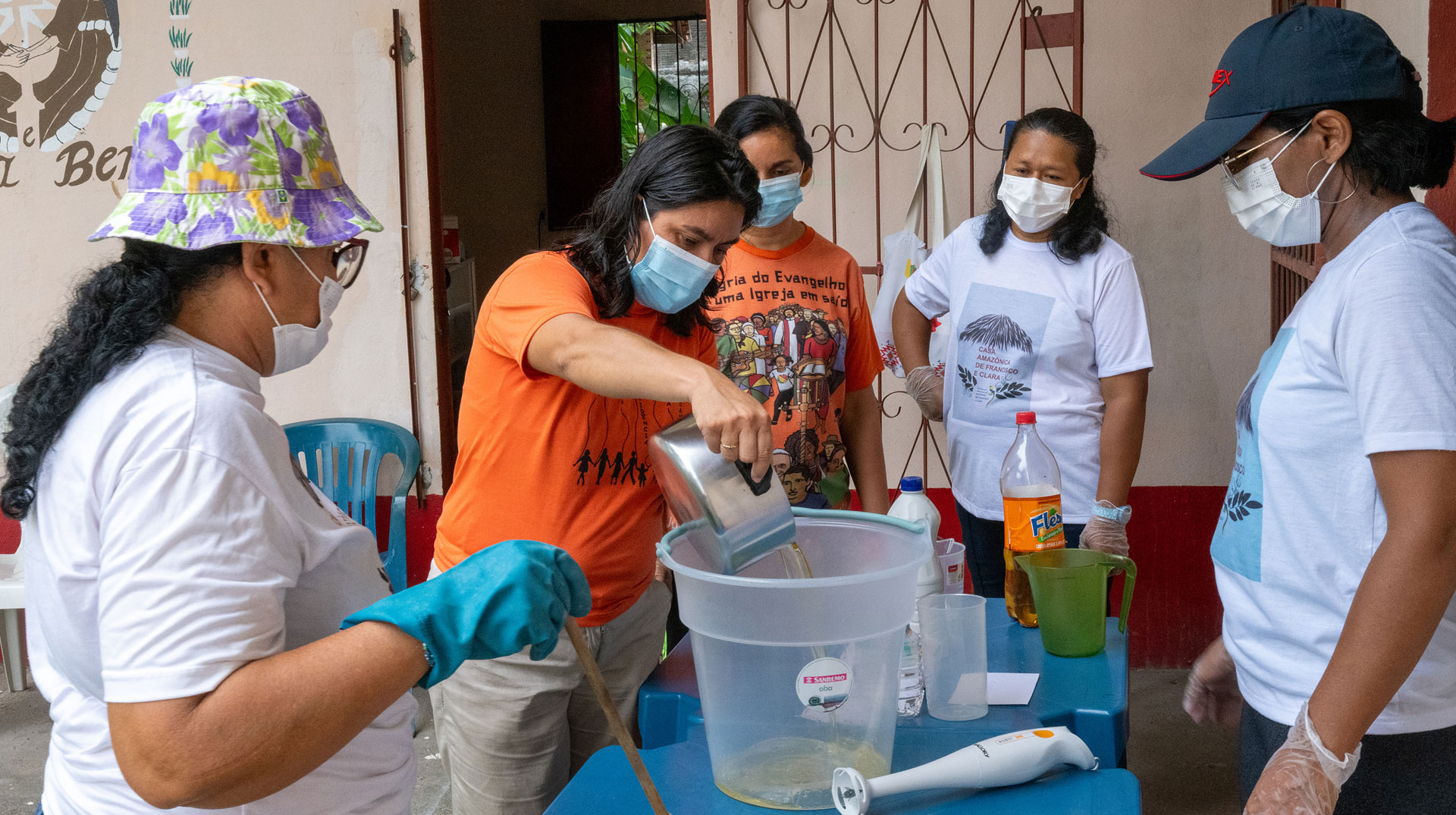Frauen schütten Flüssigkeiten in einen großen Eimer