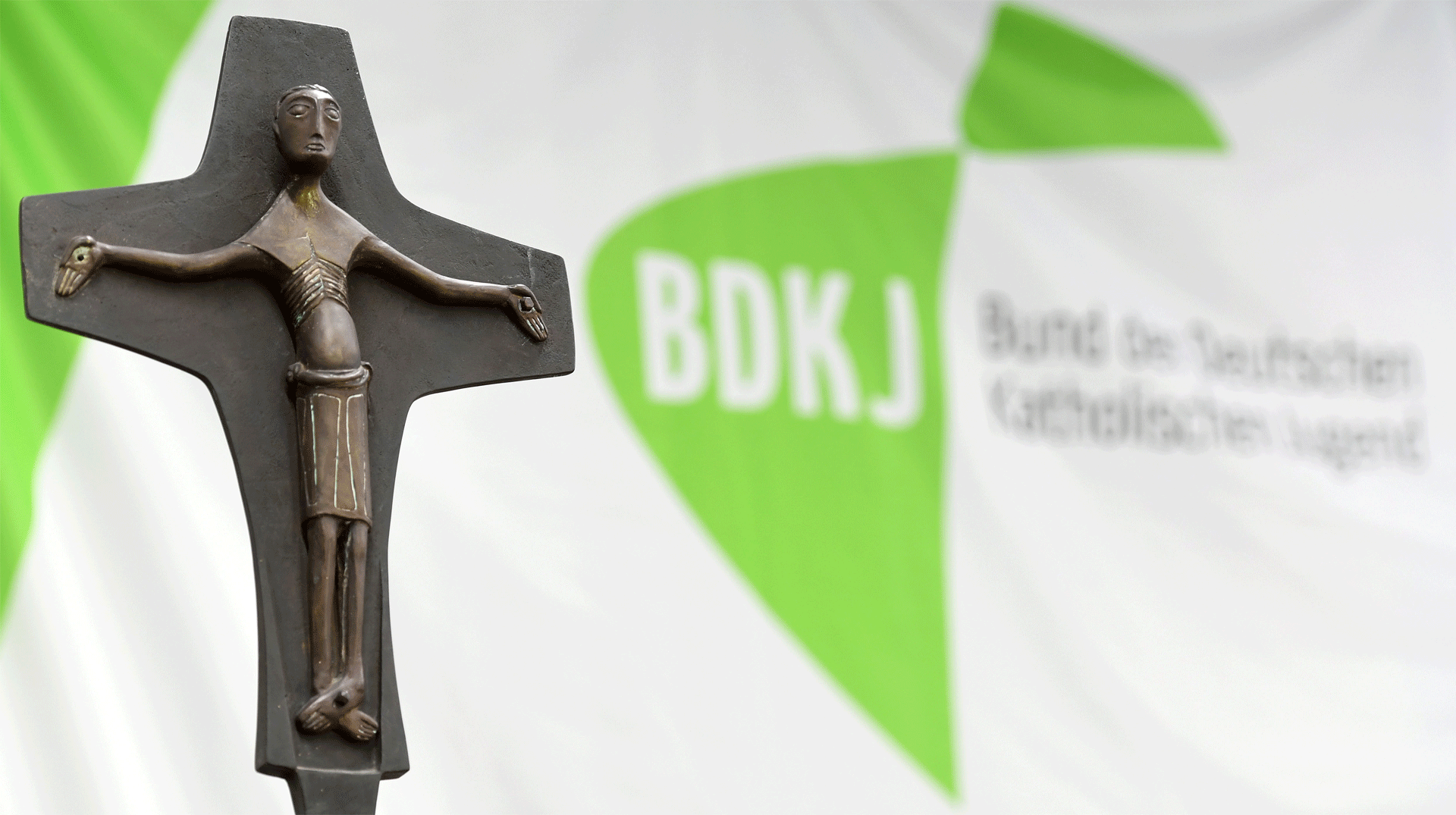 Ein Kreuz, im Hintergrund der Schriftzug "BDKJ"