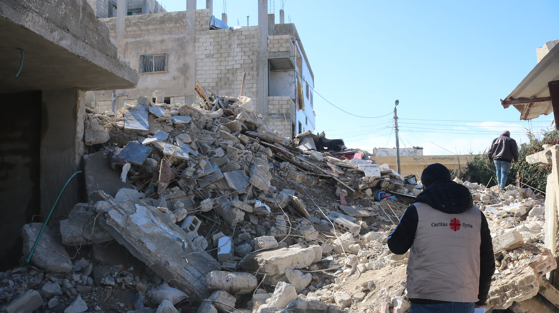Ein Nothelfer läuft über herausgebrochene Mauern nach dem Erdbeben in Syrien und der Türkei 2023.