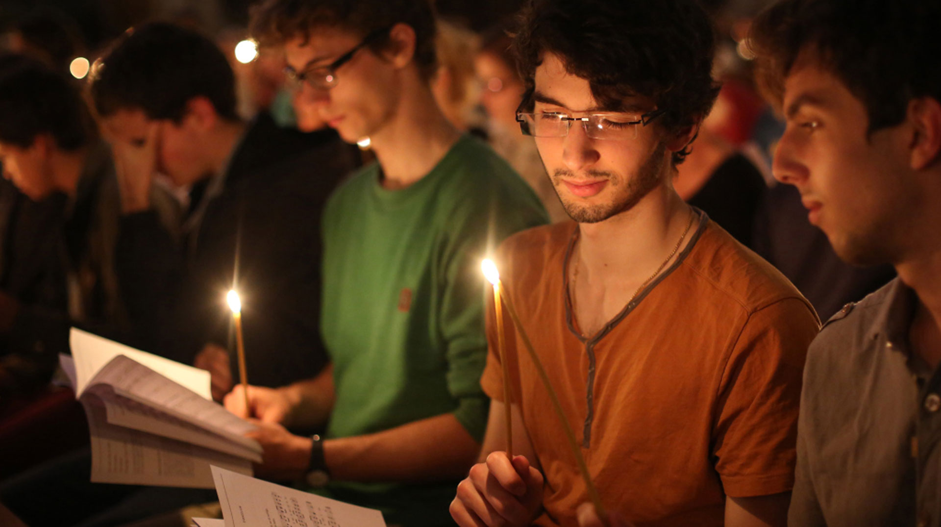 Junge Menschen mit Kerzen singen auf einem Taize-Treffen