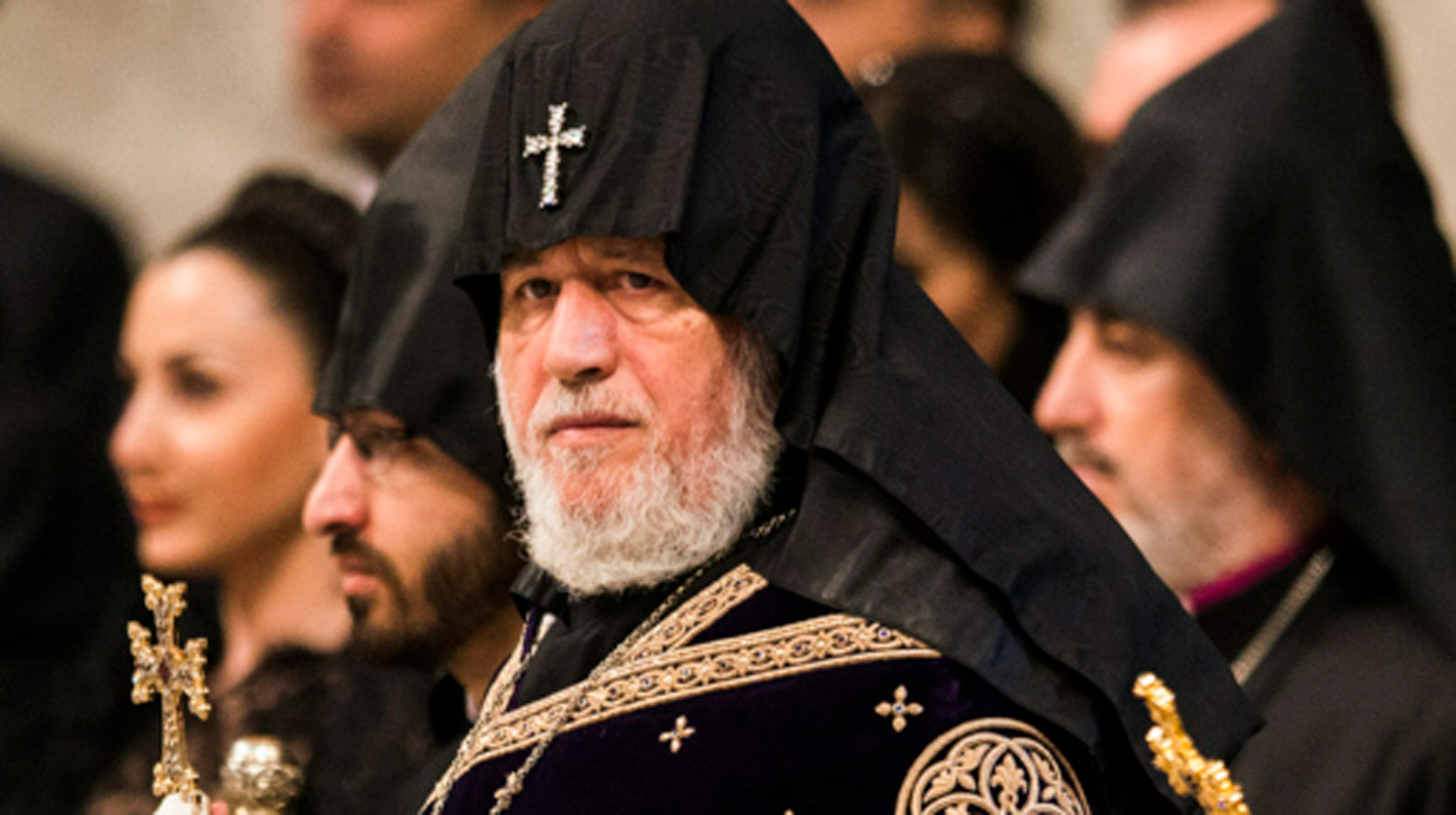 Ein Mann im Gewand eines armenisch-apostolischen Katholikos-Patriarchen hält ein Kreuz in der Hand.