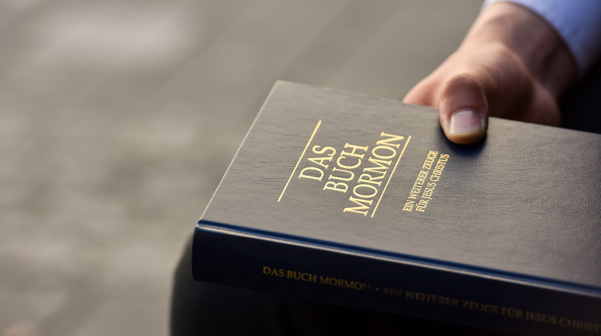 Ein Missionar der Mormonen hält ein Exemplar von "Das Buch Mormon" in der Hand, am 16. Mai 2017 in Bonn.