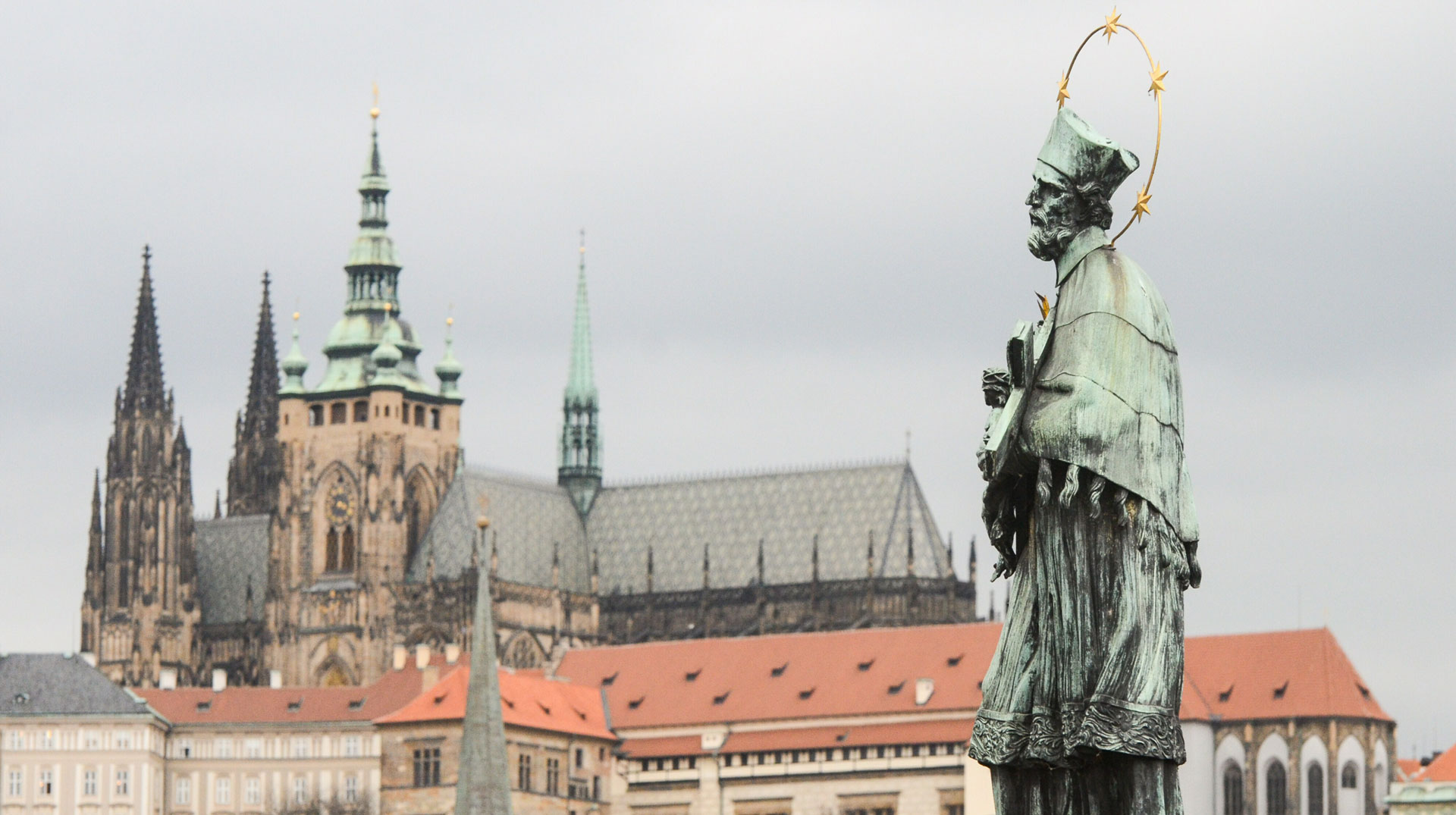Statue des heiligen Johannes von Nepomuk auf der Karlsbrücke in Prag am 21. März 2016. Im Hintergrund: der Veitsdom.
