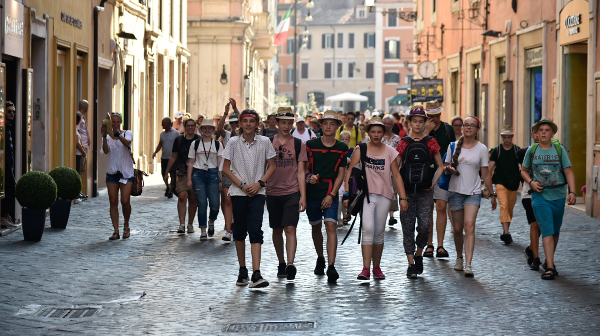 Messdiener laufen durch eine enge Gasse in Rom