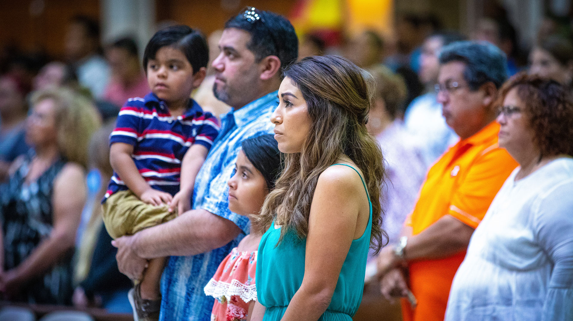 Vater, Mutter und zwei Kinder stehen zwischen anderen Gottesdienstbesuchern am 1. Juli 2018 in San Juan (USA).