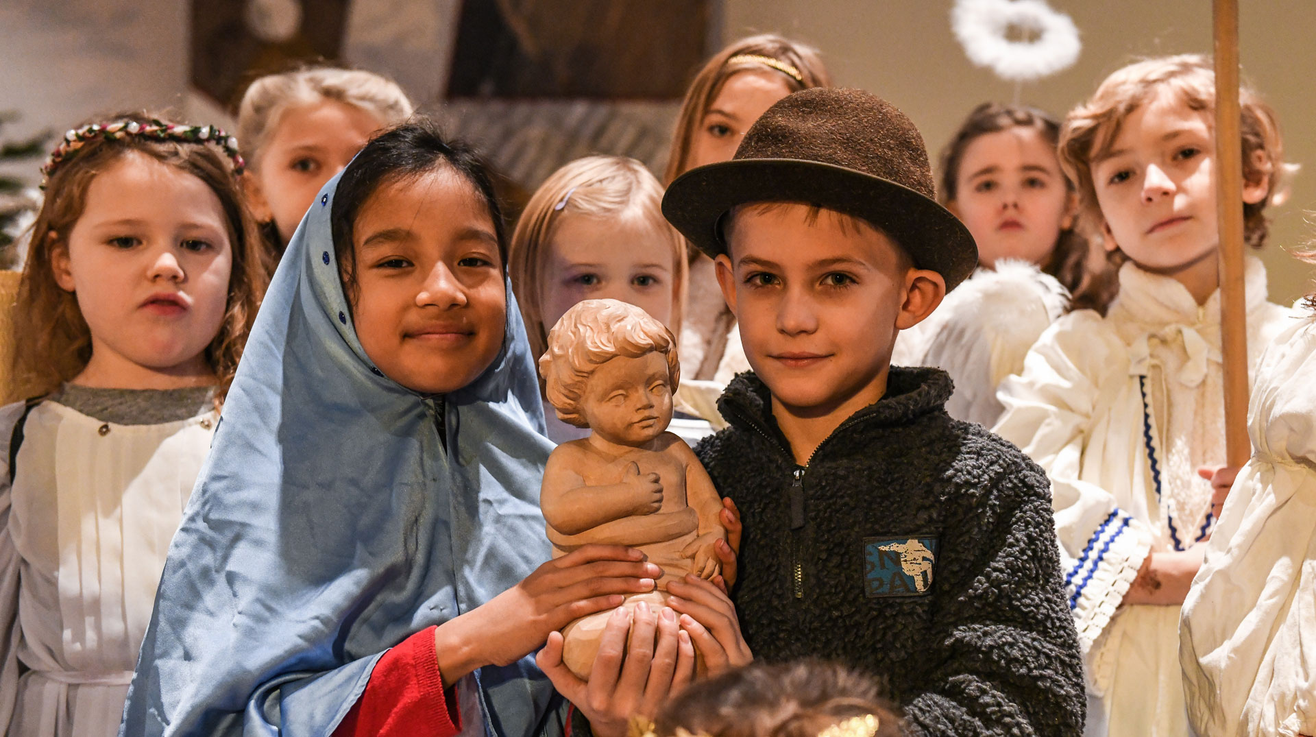 Kinder, als Maria und Josef verkleidet, bei der Probe zu einer Krippenfeier am 22. Dezember 2018 in einer Kirche in Bonn. Im Hintergrund: Kinder als Engel verkleidet.