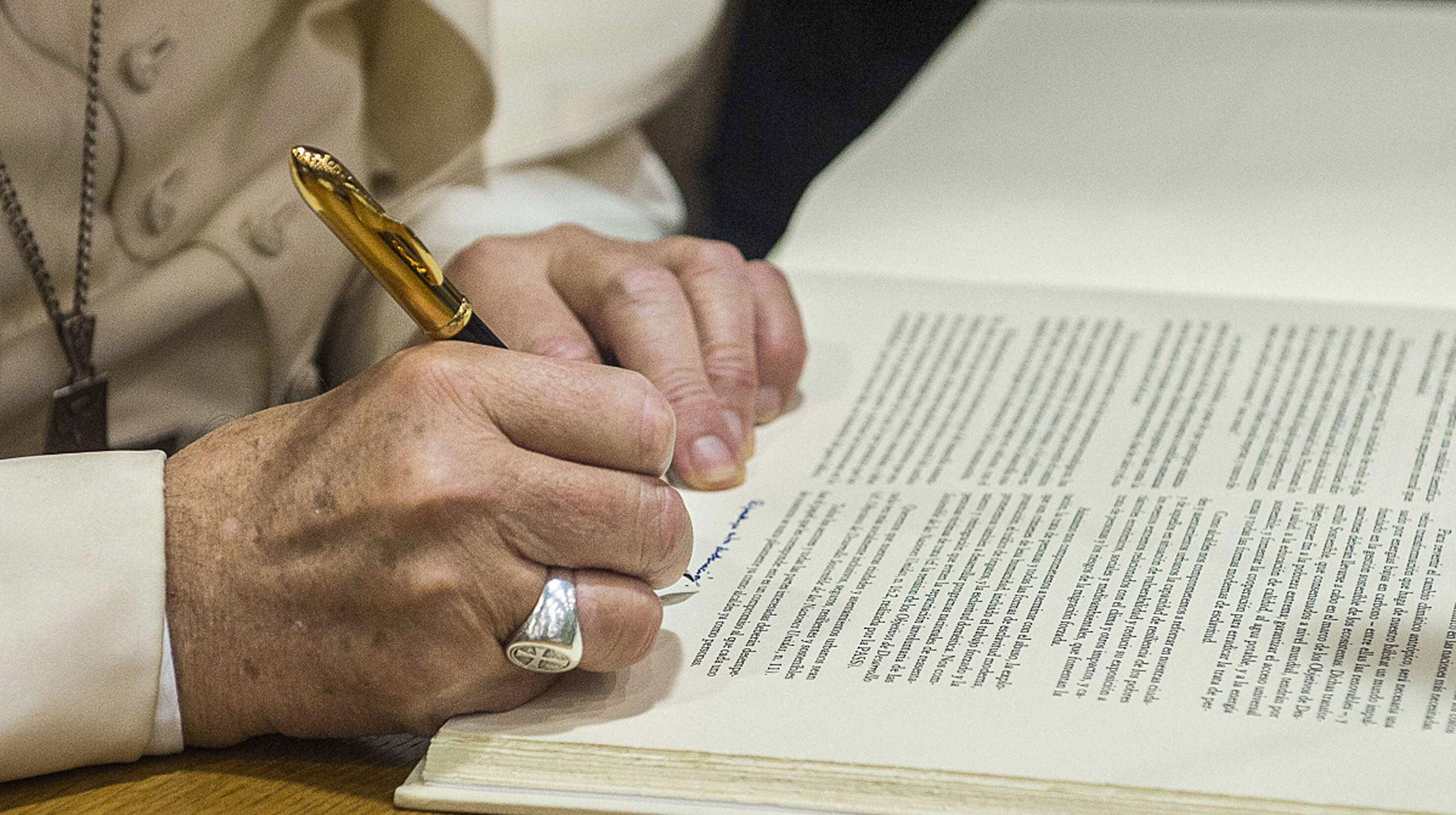 Papst Franziskus unterschreibt ein Dokument