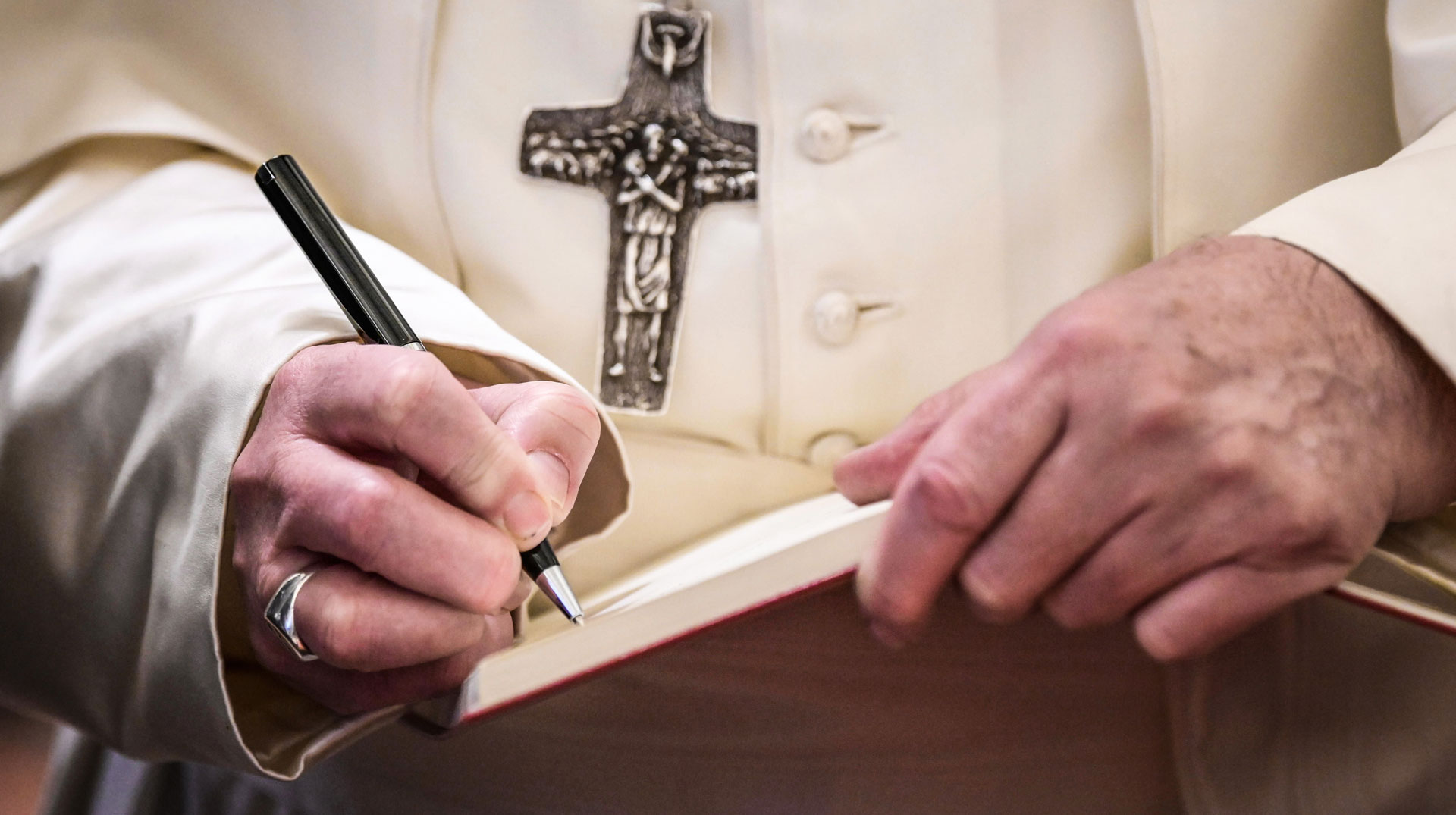 Papst Franziskus schreibt mit einem Kugelschreiber in ein Heft mit weißen Seiten am 31. Januar 2020 im Vatikan.
