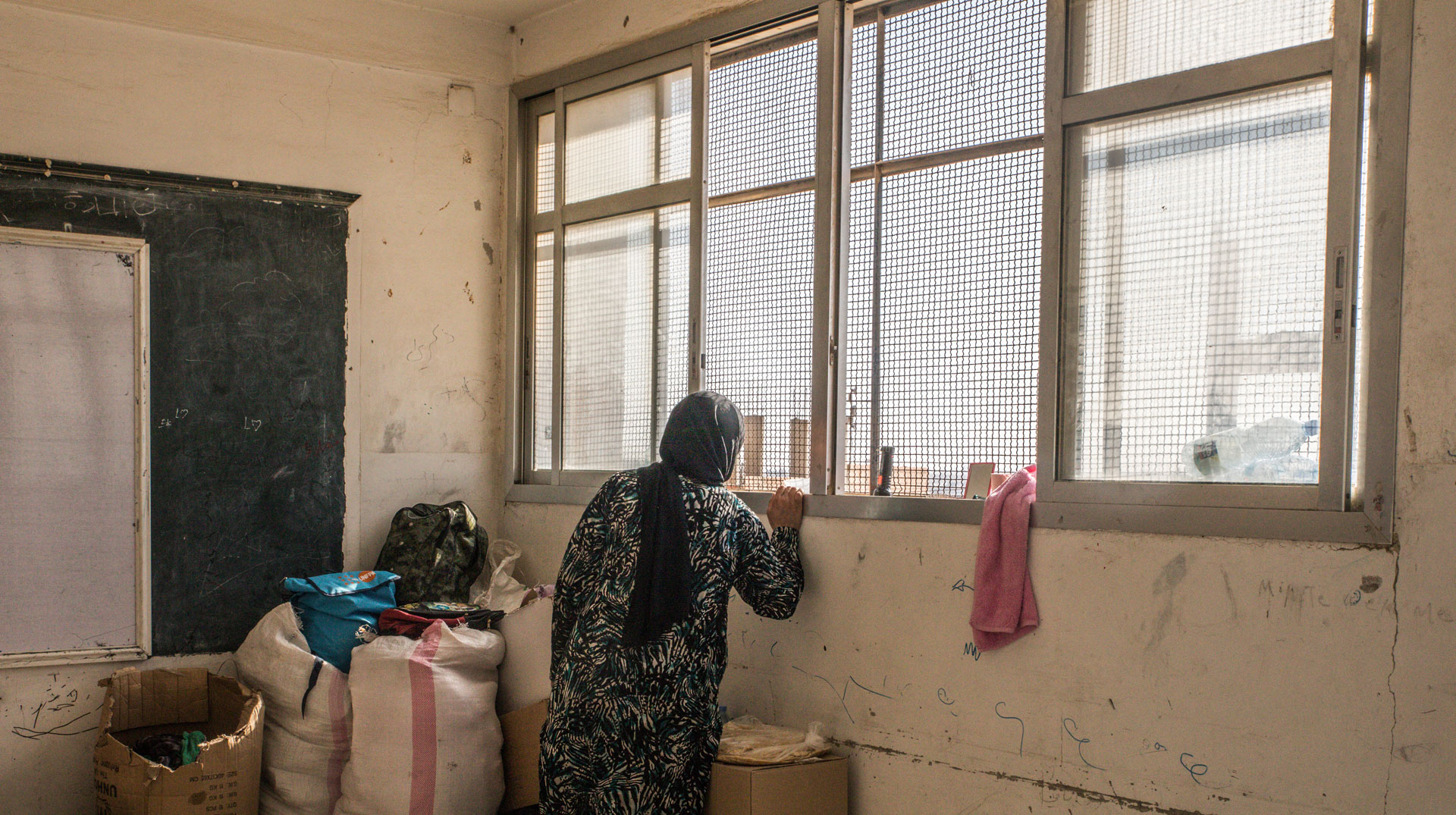 Geflüchtete Frau in leerem Klassenraum in Syrien