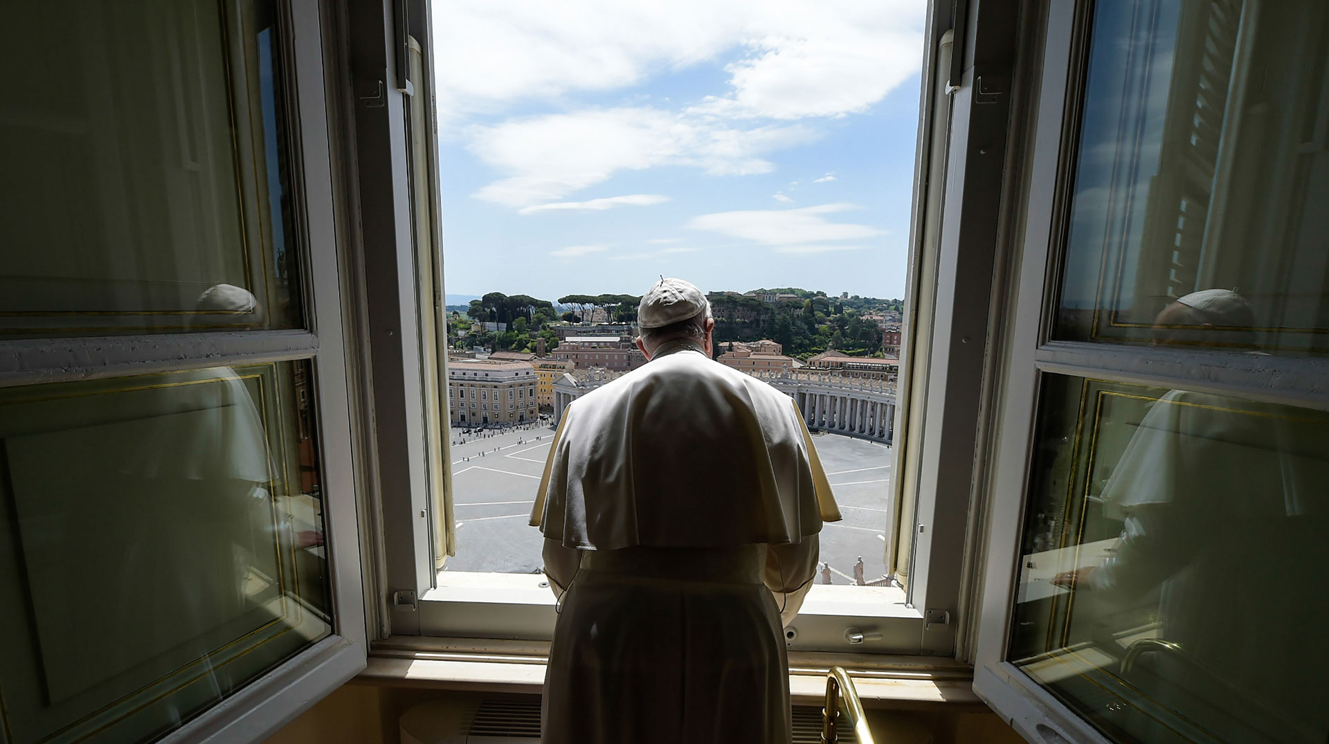 Papst Franziskus blickt durch ein Fenster des Apostolischen Palasts auf den leeren Petersplatz am 10. Mai 2020 im Vatikan.