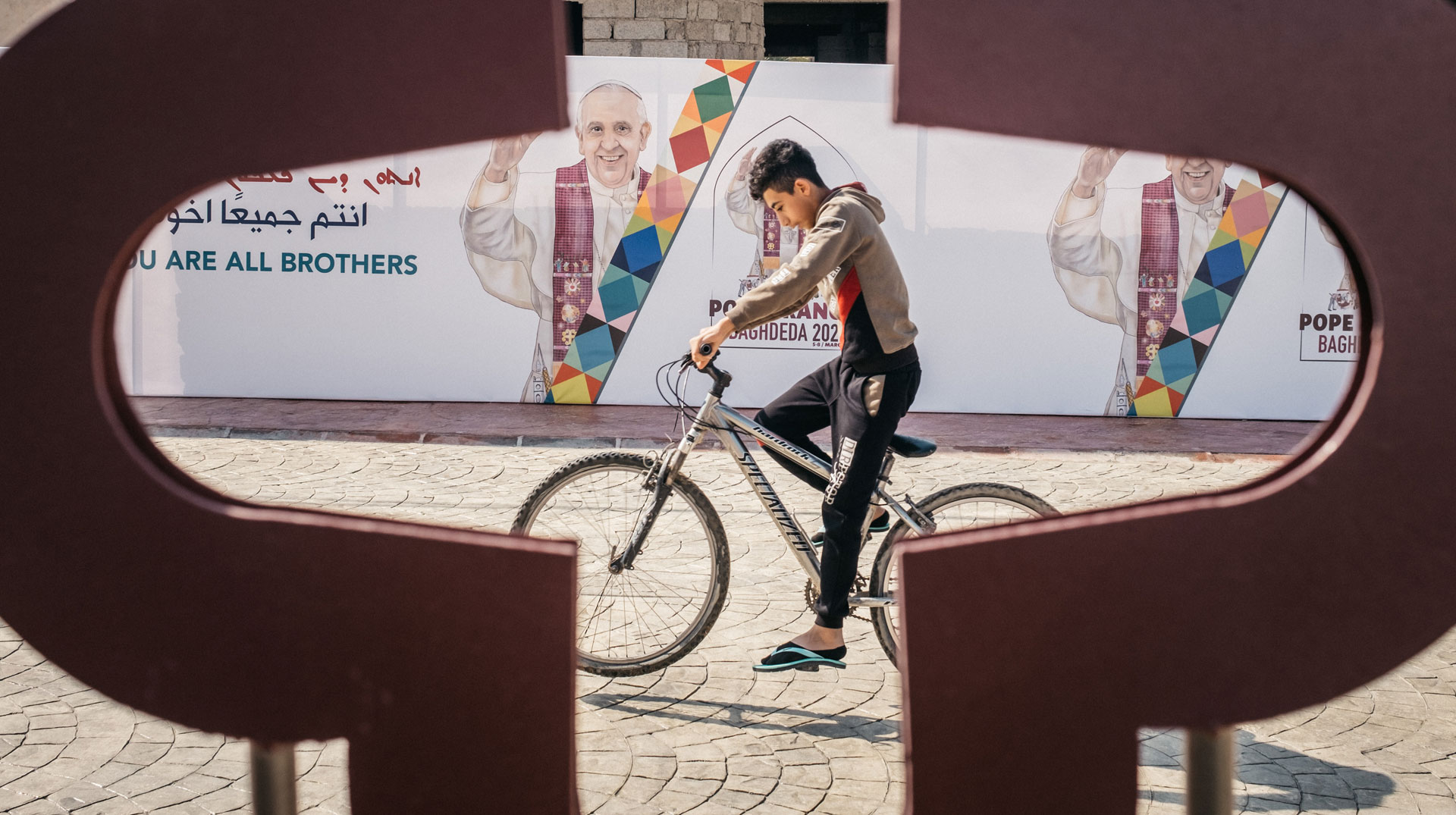 Ein Junge fährt am Vorabend des Besuchs von Papst Franziskus auf einem Fahrrad vorbei an der syrisch-katholischen Kirche al-Tahira in Karakosch am 6. März 2021.