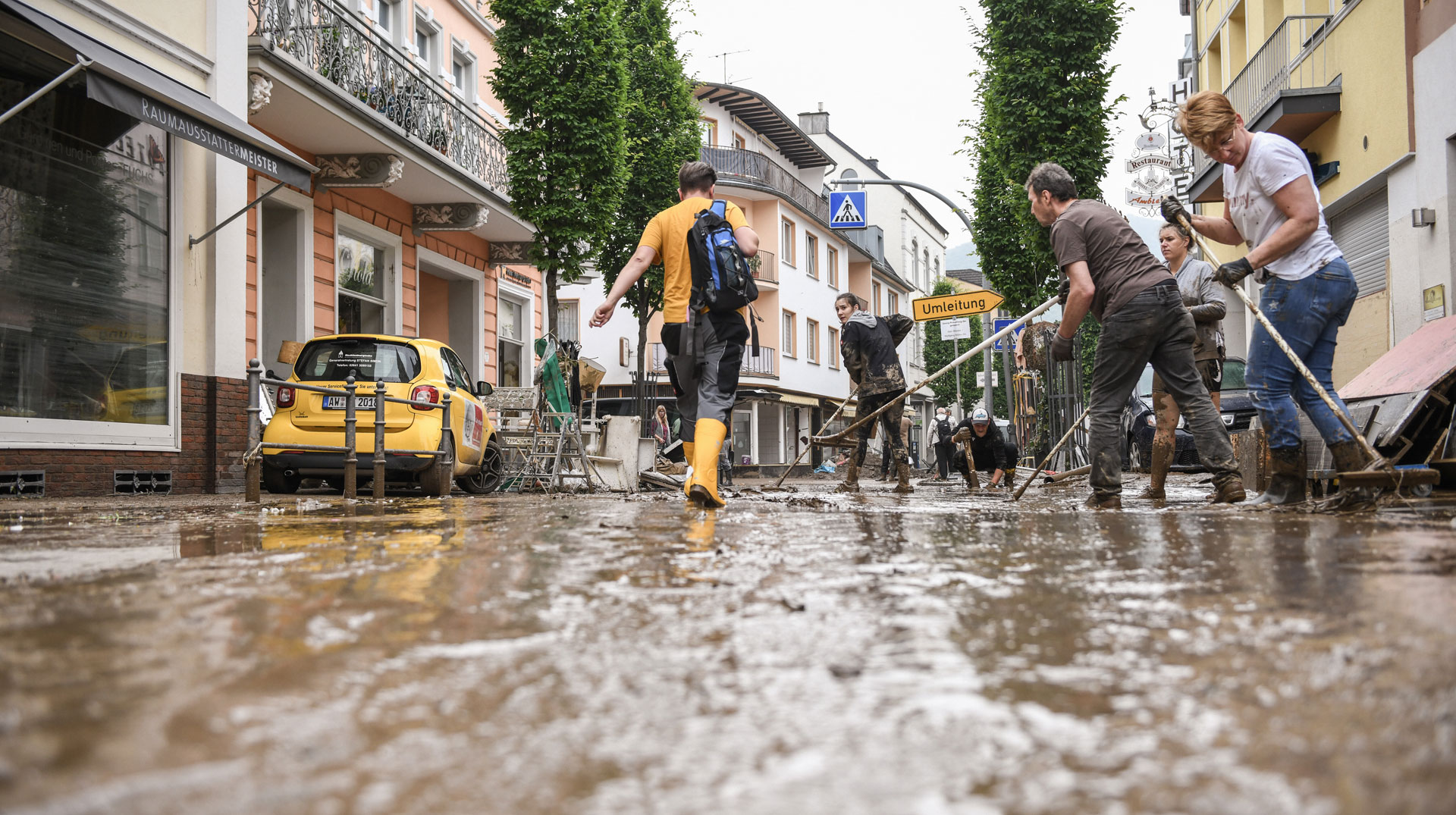Helfer in einer mit Schlamm bedeckten Straße in Bad Neuenahr am 16. Juli 2021 nachdem ein Hochwasser die Stadt überschwemmt hat.