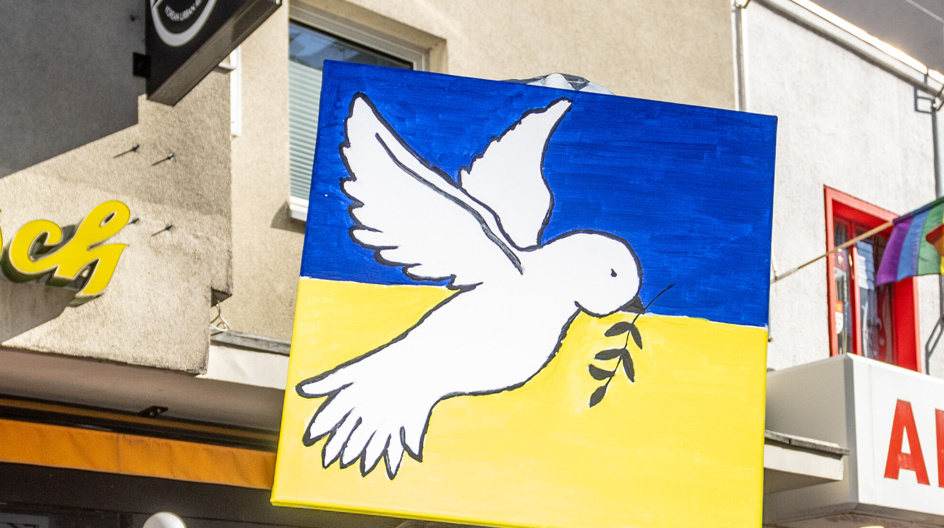 lakat mit einer Friedenstauben auf gelb-blauem Grund, den Farben der Nationalflagge der Ukraine, während einer Friedensdemonstration gegen den Krieg in der Ukraine am Rosenmontag, den 28. Februar 2022 in Köln.