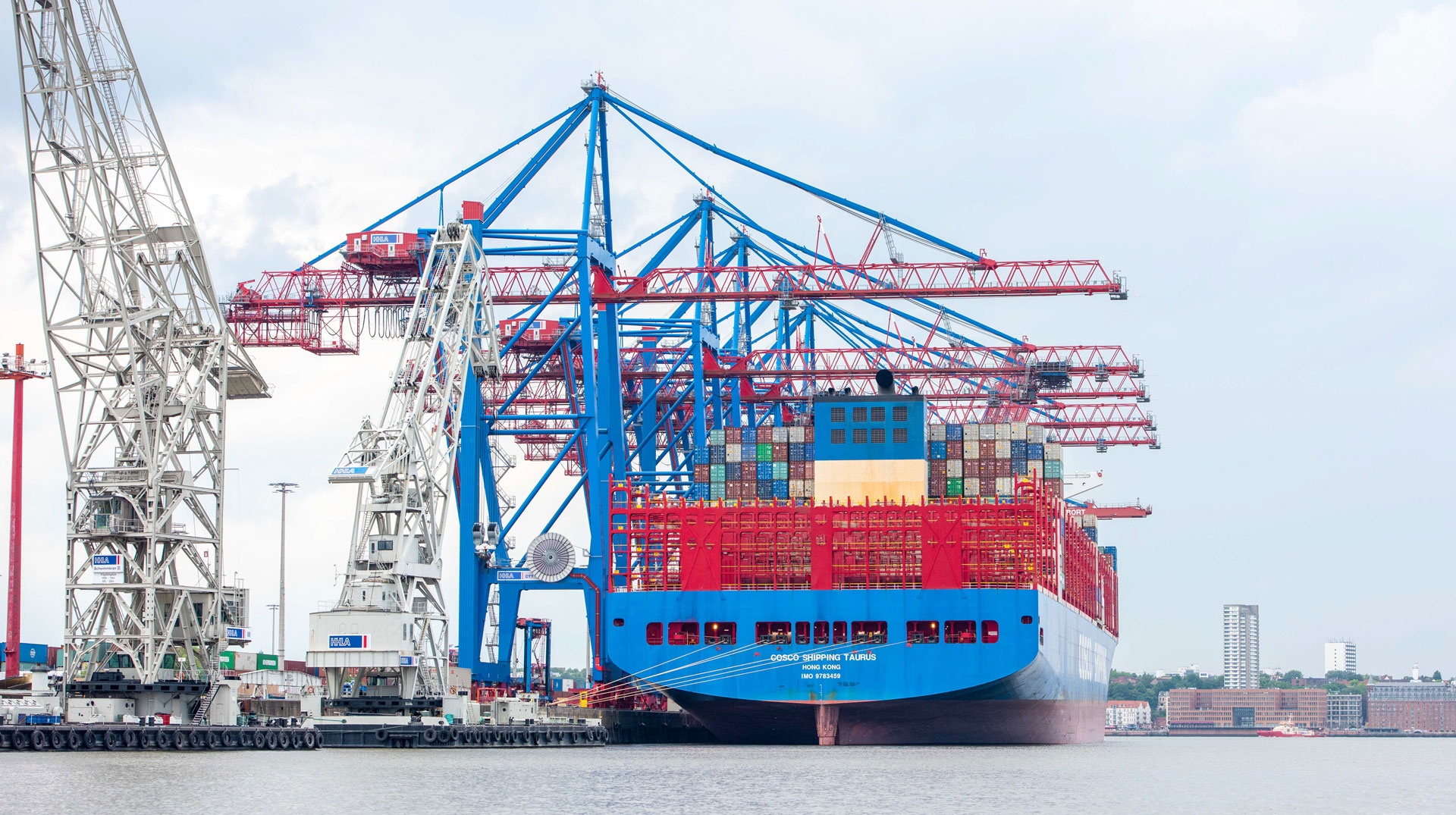 Ein Containerschiff liegt im Hafen von Hamburg am 3. Juli 2020 und wird gelöscht. Kräne ragen über das Schiff.