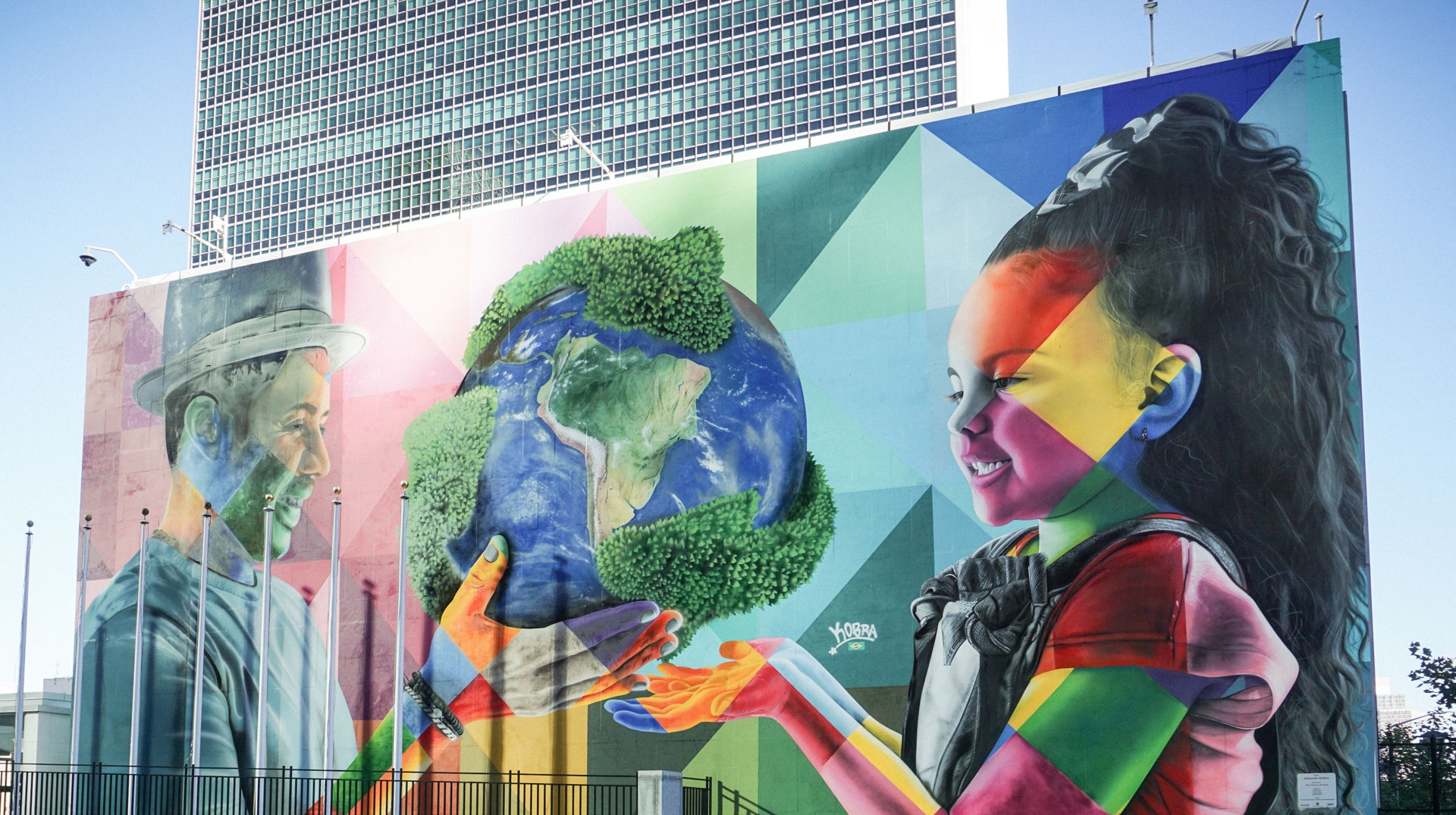Ein Wandbild von Eduardo Kobra vor dem Hauptquartier der United Nations (UN), das zwei junge Menschen zeigt, die eine Weltkugel halten, am 8. Oktober 2022 in New York (USA).