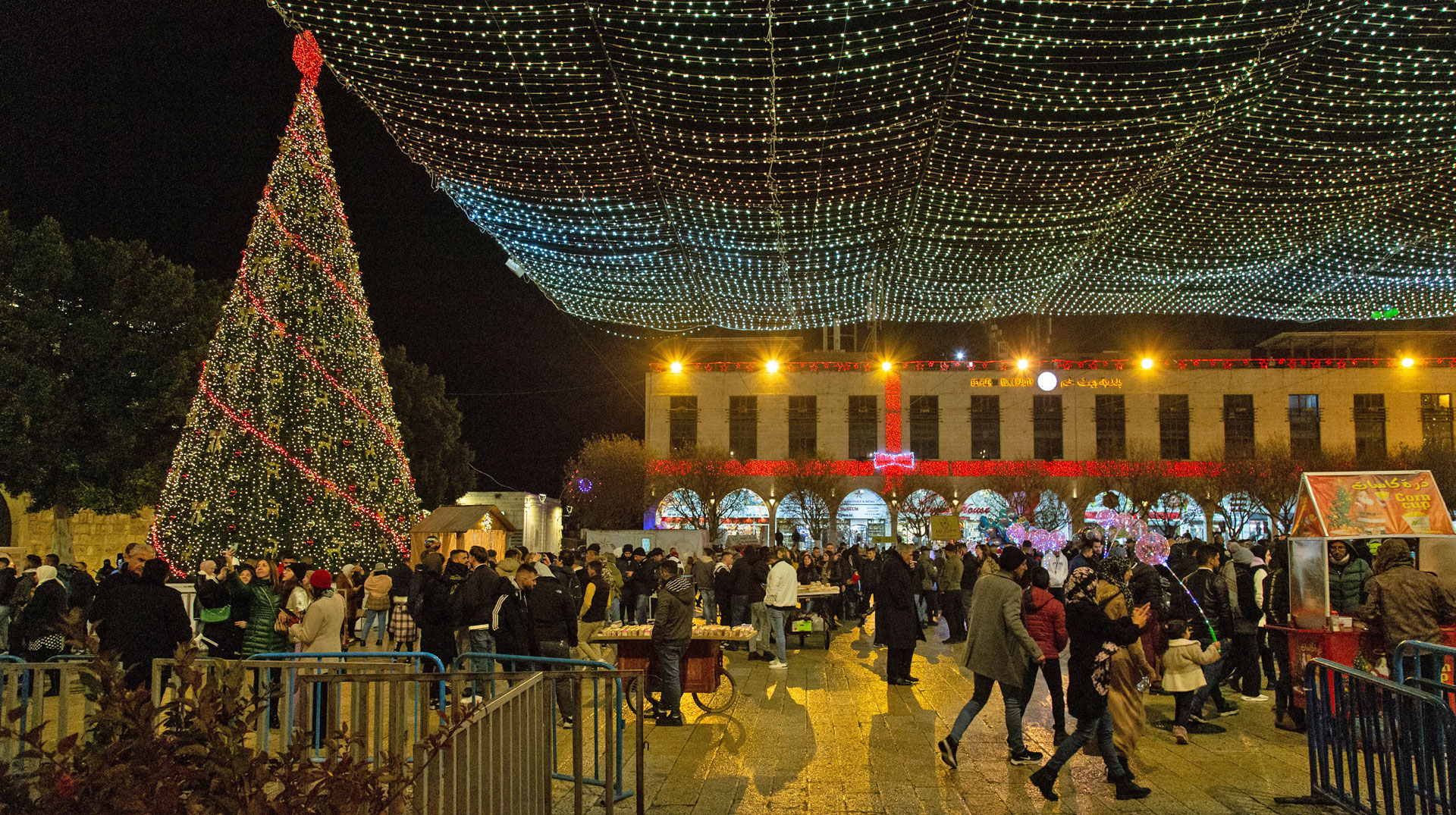 Der festlich beleuchtete Krippenplatz mit geschmücktem Weihnachtsbaum zu Weihnachten am Heiligabend, dem 24. Dezember 2022, in der Altstadt von Bethlehem (Palästinensische Autonomiegebiete).