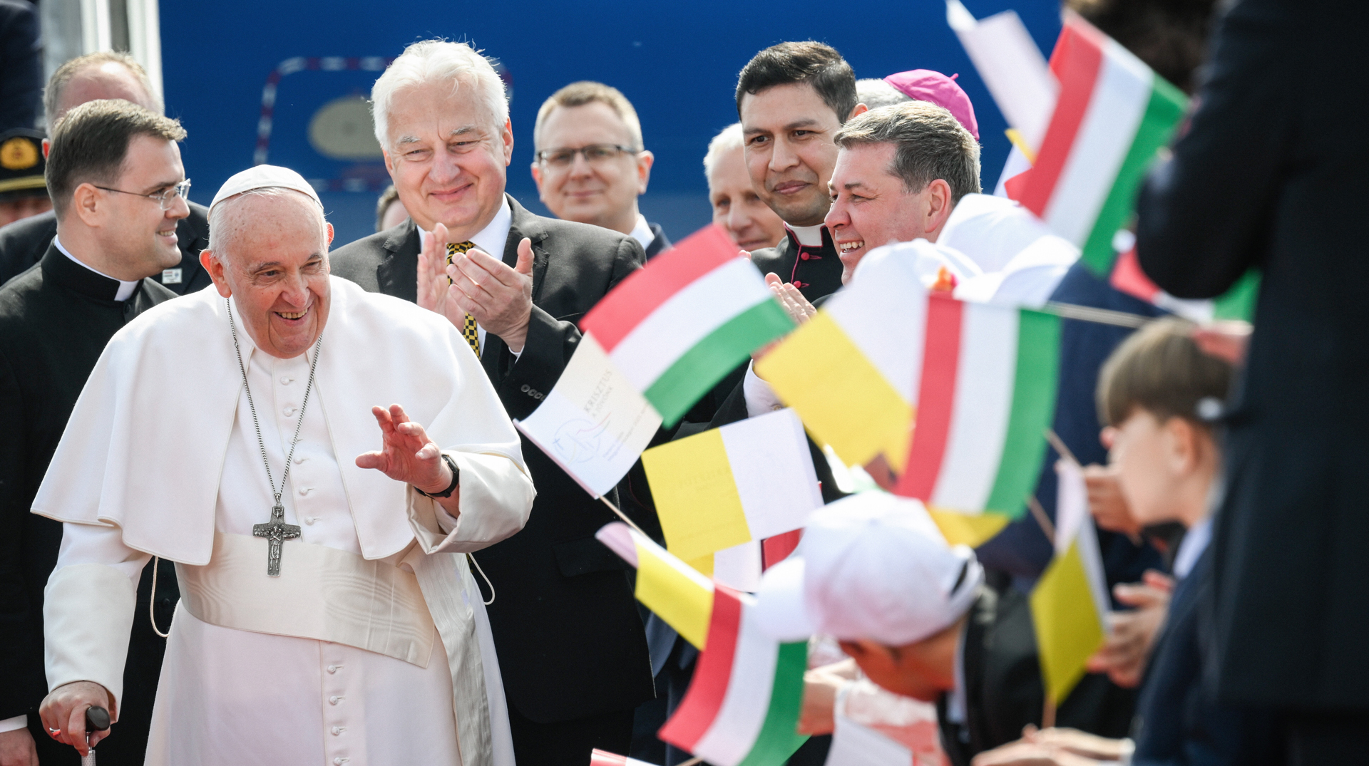 Menschen schwenken kleine Fähnchen mit den ungarischen Nationalfarben beim Empfang für Papst Franziskus am 28. April 2023