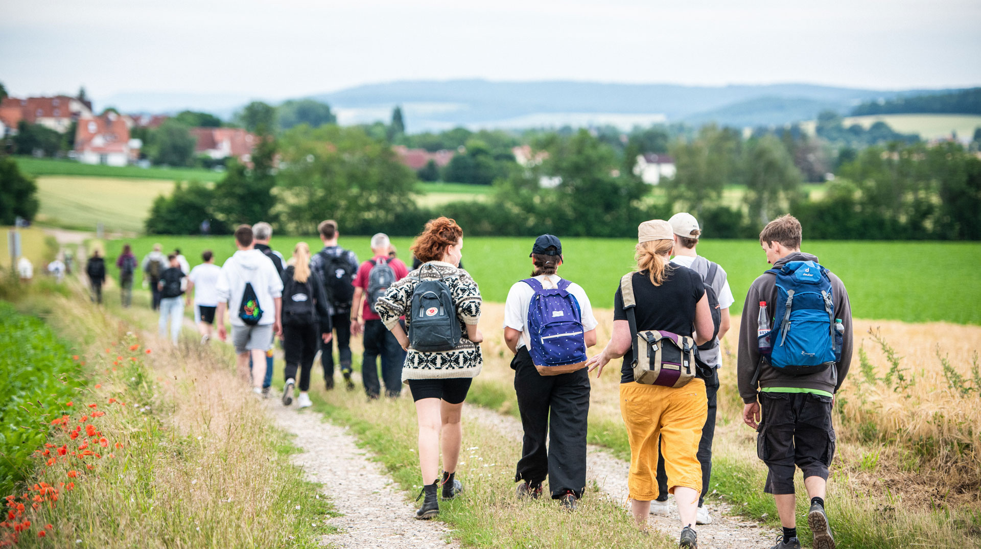 Junge Menschen mit Rucksäcken wandern zu Fuß am 1. Juli 2023 in Göttingen. Symbolbild Pilgern, Auf dem Weg