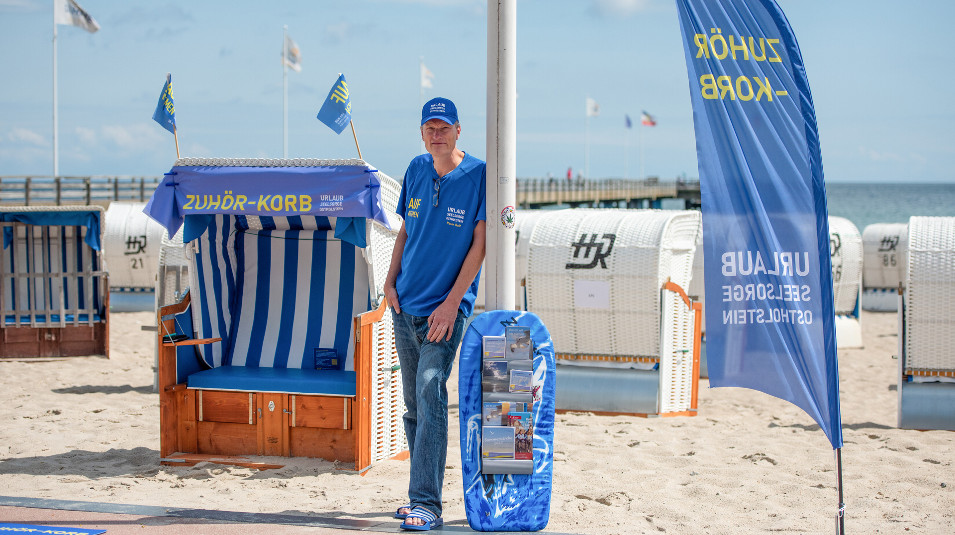 Urlauberseelsorger Pater Ralf Winterberg sitzt am 12. Juli 2023 in seinem "Zuhör-Korb" im Ostseebad Dahme.