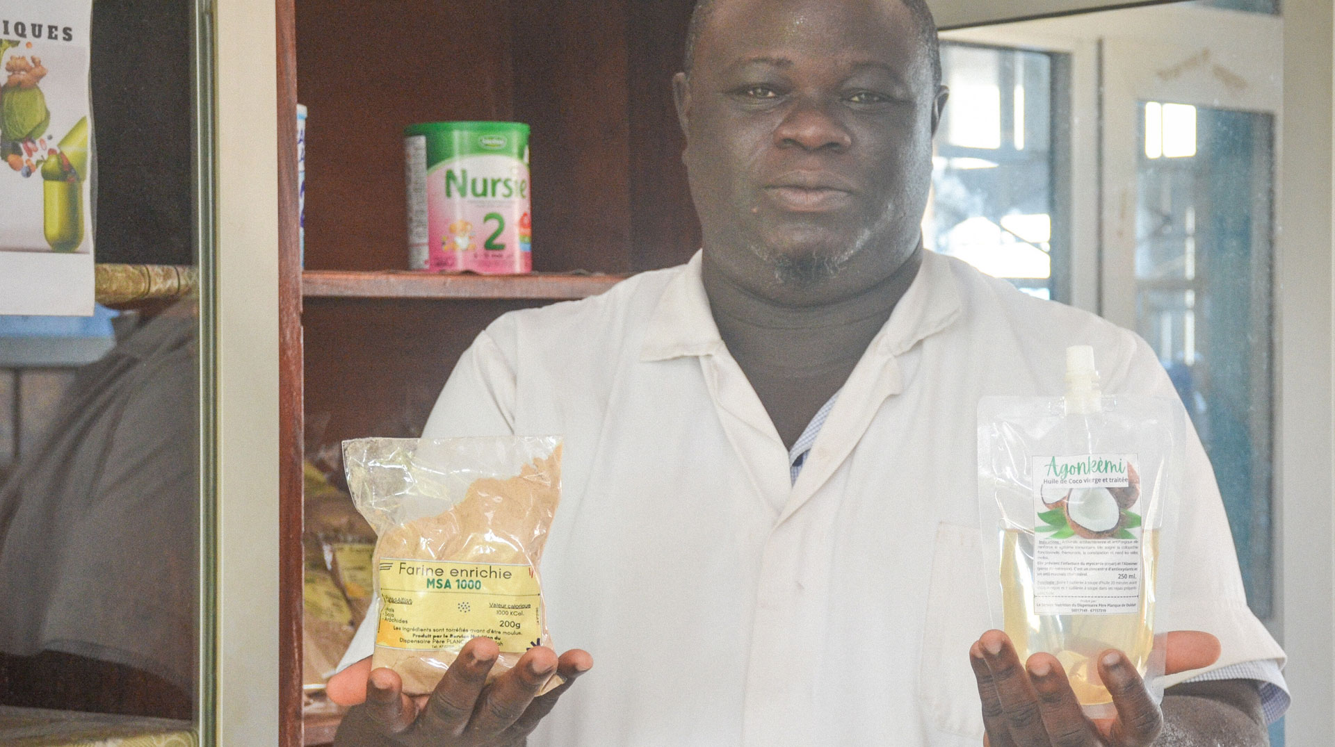 Samuel Gbaguidi, Ernährungsberater, zeigt lokale Produkte wie Mehl aus Soya, Erdnüssen und Mais sowie Kokosmilch gegen Mangelernährung am 10. Oktober 2023 in einem Waisenhaus in Ouidah (Benin).