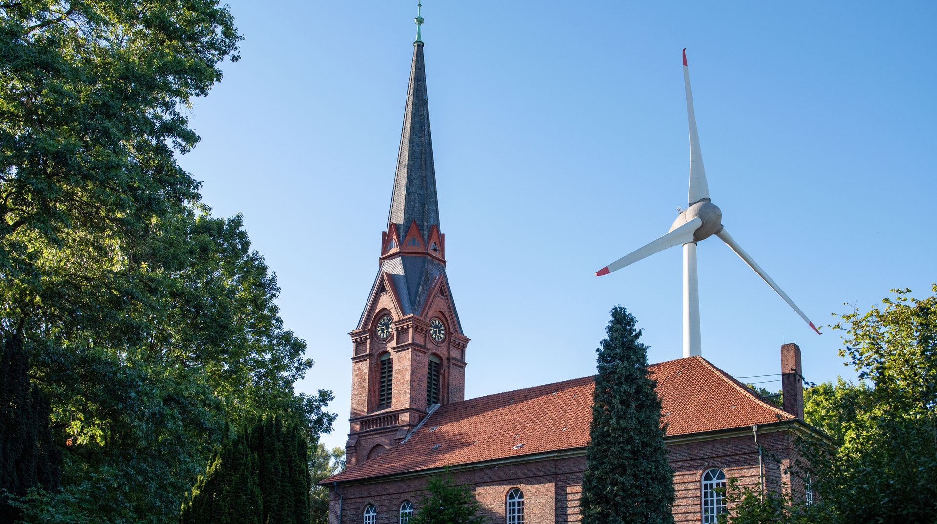 Sankt Gertrudkirche Altenwerder am 6. September 2023 in Hamburg. Hinter dem Kirchturm ist ein Windrad zu sehen.
