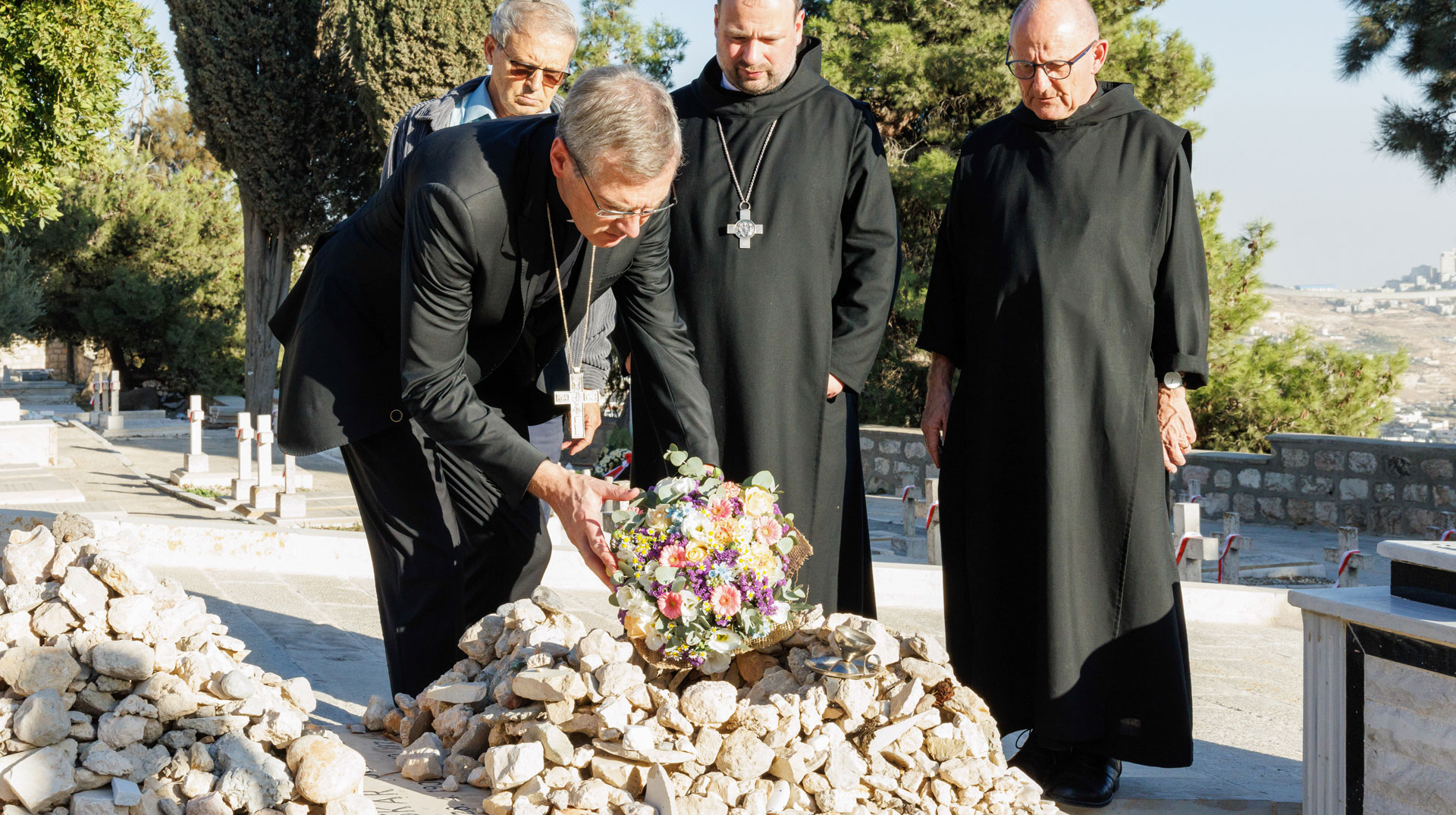Bischof Heiner Wilmer (Hildesheim) legt Blumen auf das Grab von Oskar Schindler in Jerusalem