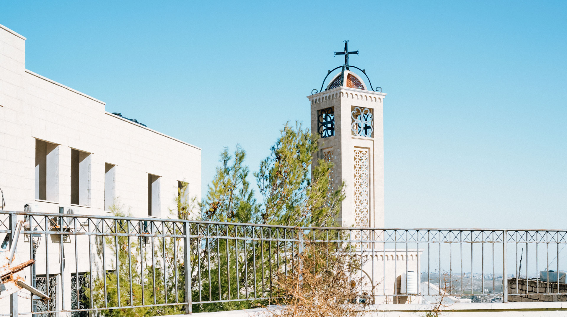 Blick auf einen Kirchturm in Bethlehem (Palästinensische Gebiete) am 22. Dezember 2023. Eine schwarze Katze läuft vorbei.