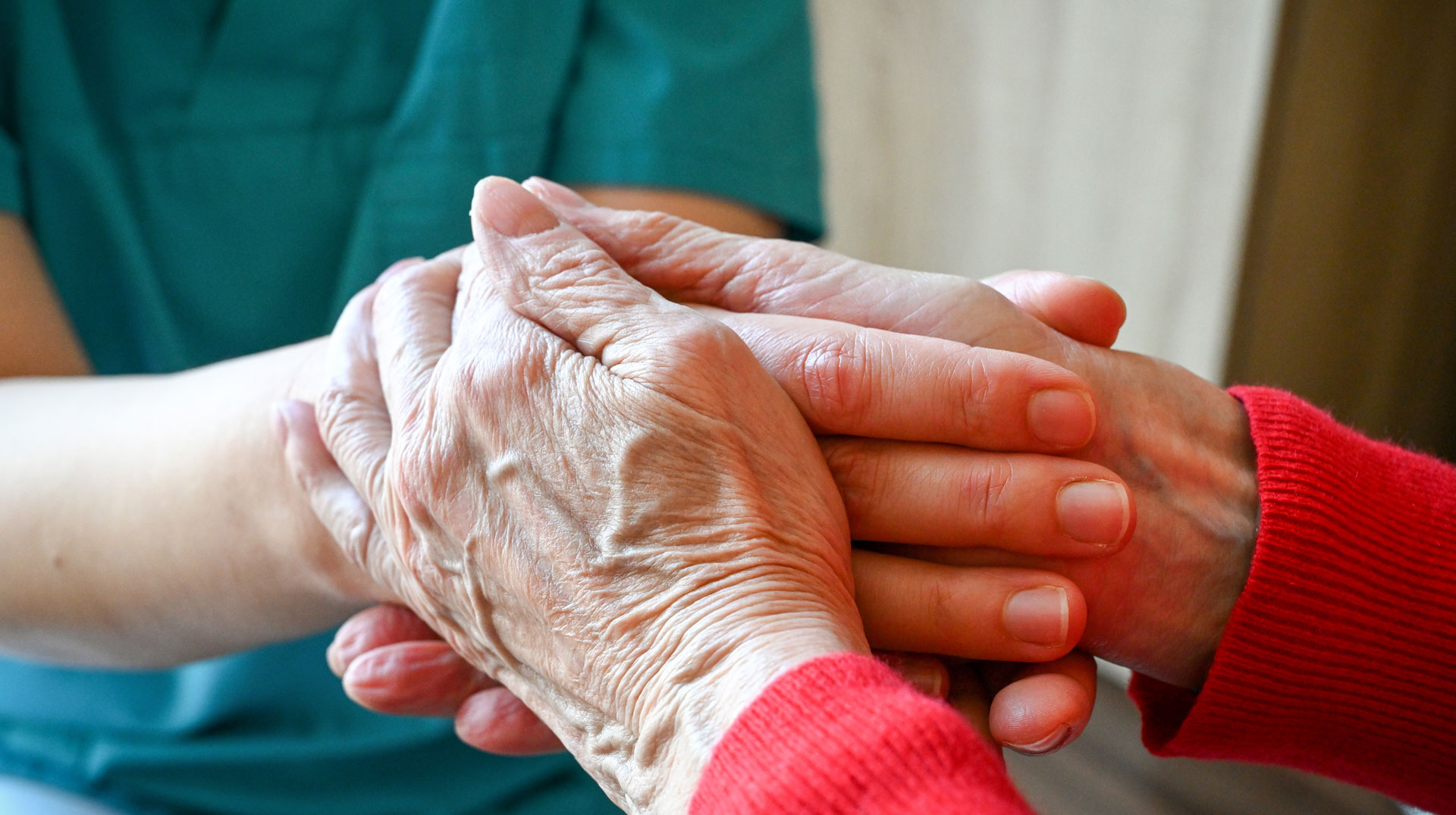 Eine Pflegerin hält die Hände einer Bewohnerin, am 1. Februar 2024 in einem Caritas-Seniorenheim in Gießen.
