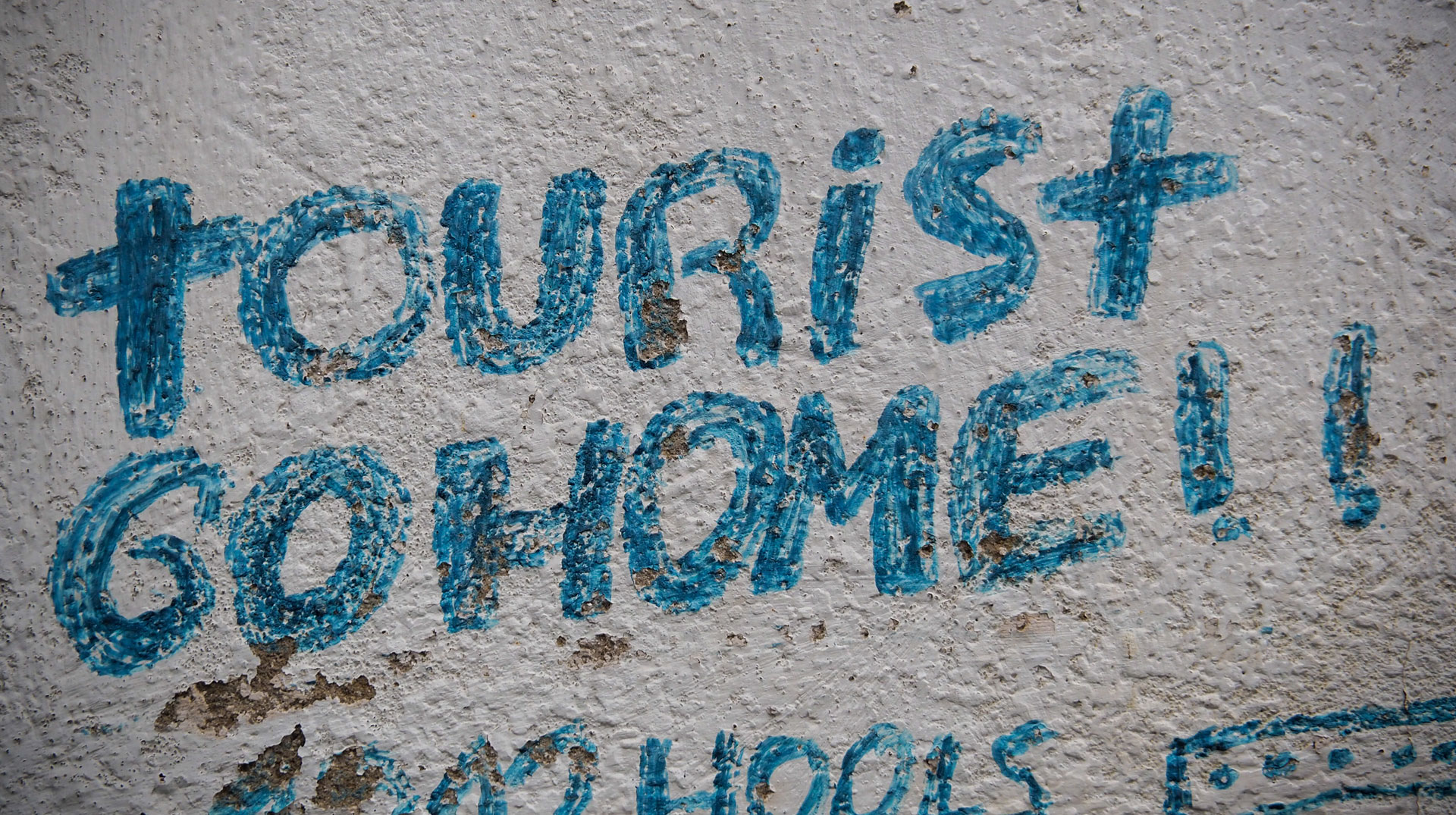 Protest-Pinselei "Tourists go home!" - "Touristen haut ab nach Hause" - auf einer Hauswand in Santiago de Compostela (Spanien) am 30. Mai 2024.