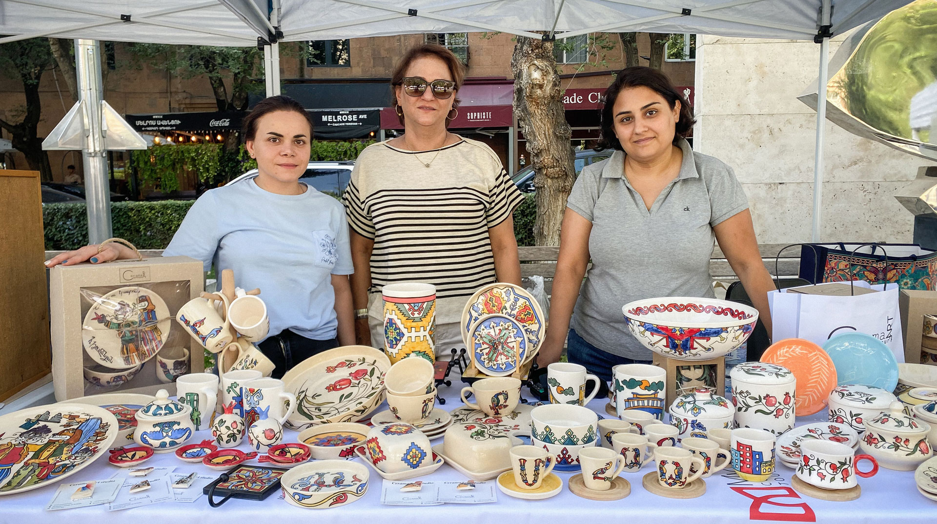 Aus Bergkarabach geflüchtete Frauen, darunter Azatoohi Simonian (r.), verkaufen an einem Marktstand Töpferware, am 15. September 2024 in Jerewan (Armenien).