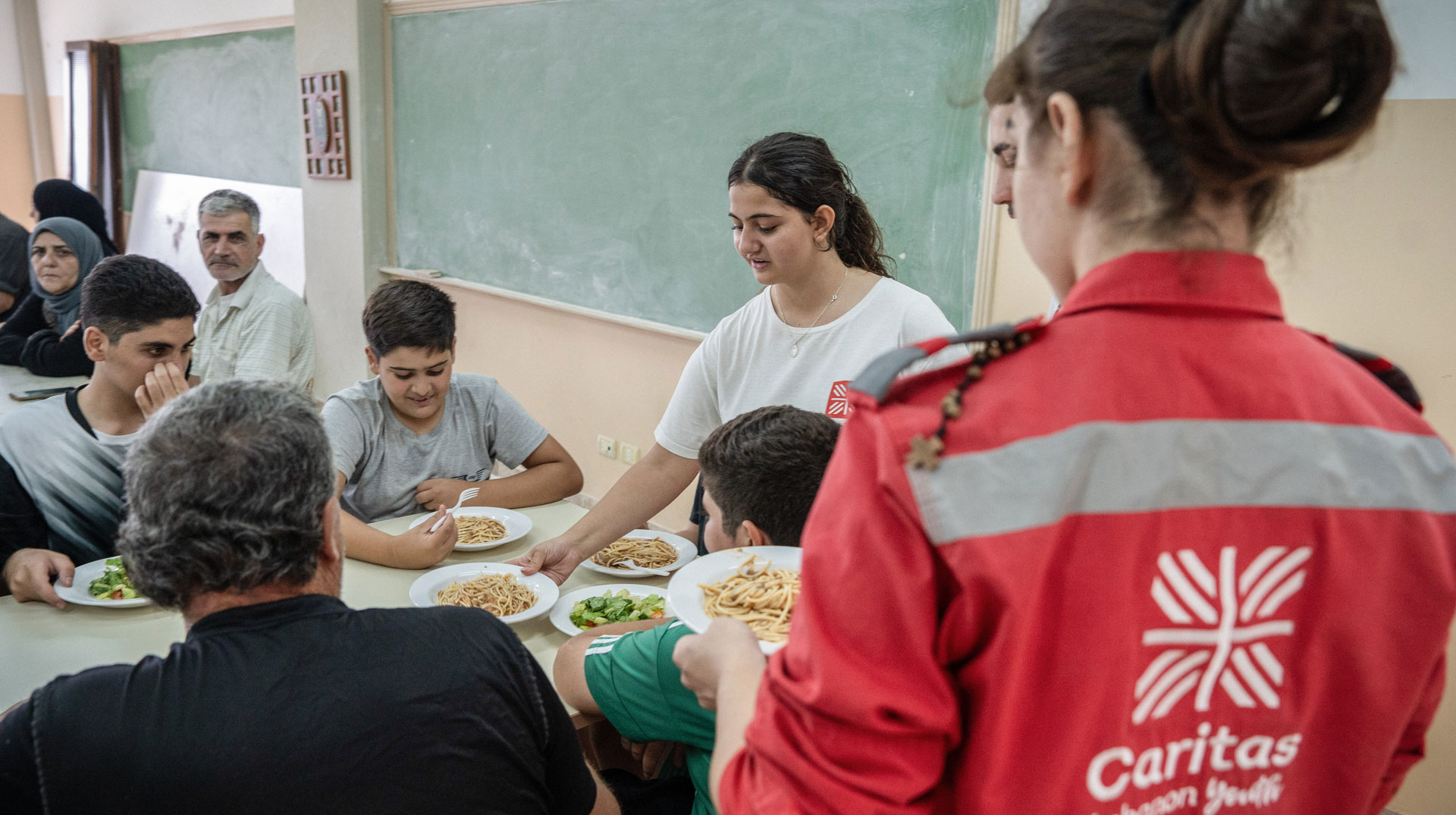 Helferinnen der Caritas bei der Essensausgabe für die Bewohner, in der Mensa, in einer Flüchtlingsunterkunft für Binnengeflüchtete im Libanon am 12. Oktober 2024 in Beit Chebeb (Libanon).