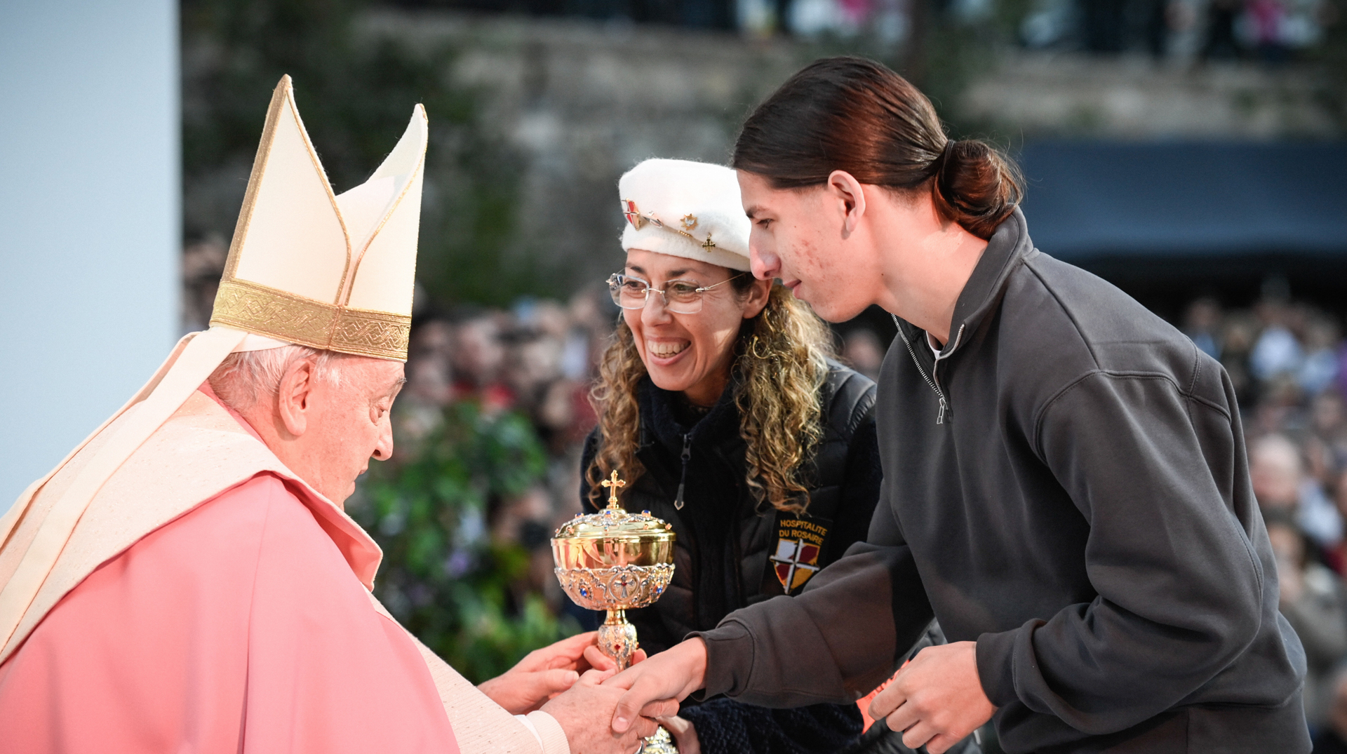 Gottesdienst mit Papst Franziskus, zwei Frauen bringen die Gaben und geben ihm die Hand, am 15. Dezember 2024 auf der Place d Austerlitz in Ajaccio (Frankreich).