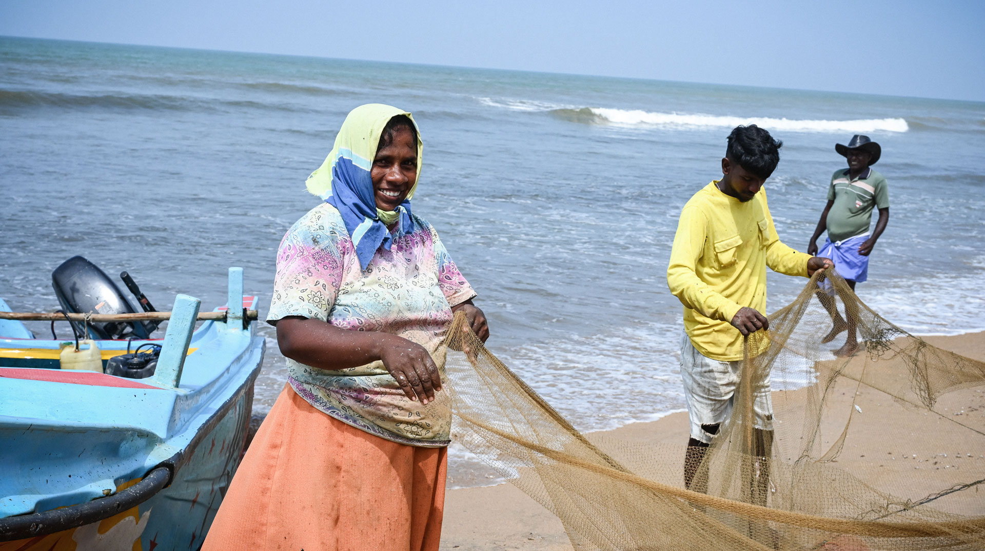 Eine Frau und ein Mann mit einem Fischernetz am Strand von Payagala (Sri Lanka) am 11. Februar 2025.