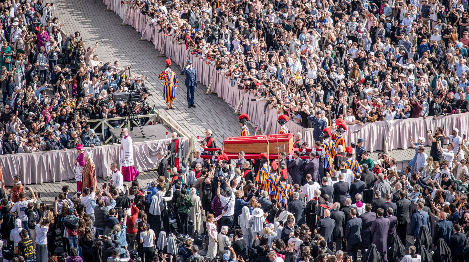 Sargträger tragen den offenen Sarg mit dem Leichnam von Papst Franziskus am 23. April 2025 durch die Menschenmenge über den Petersplatz im Vatikan.