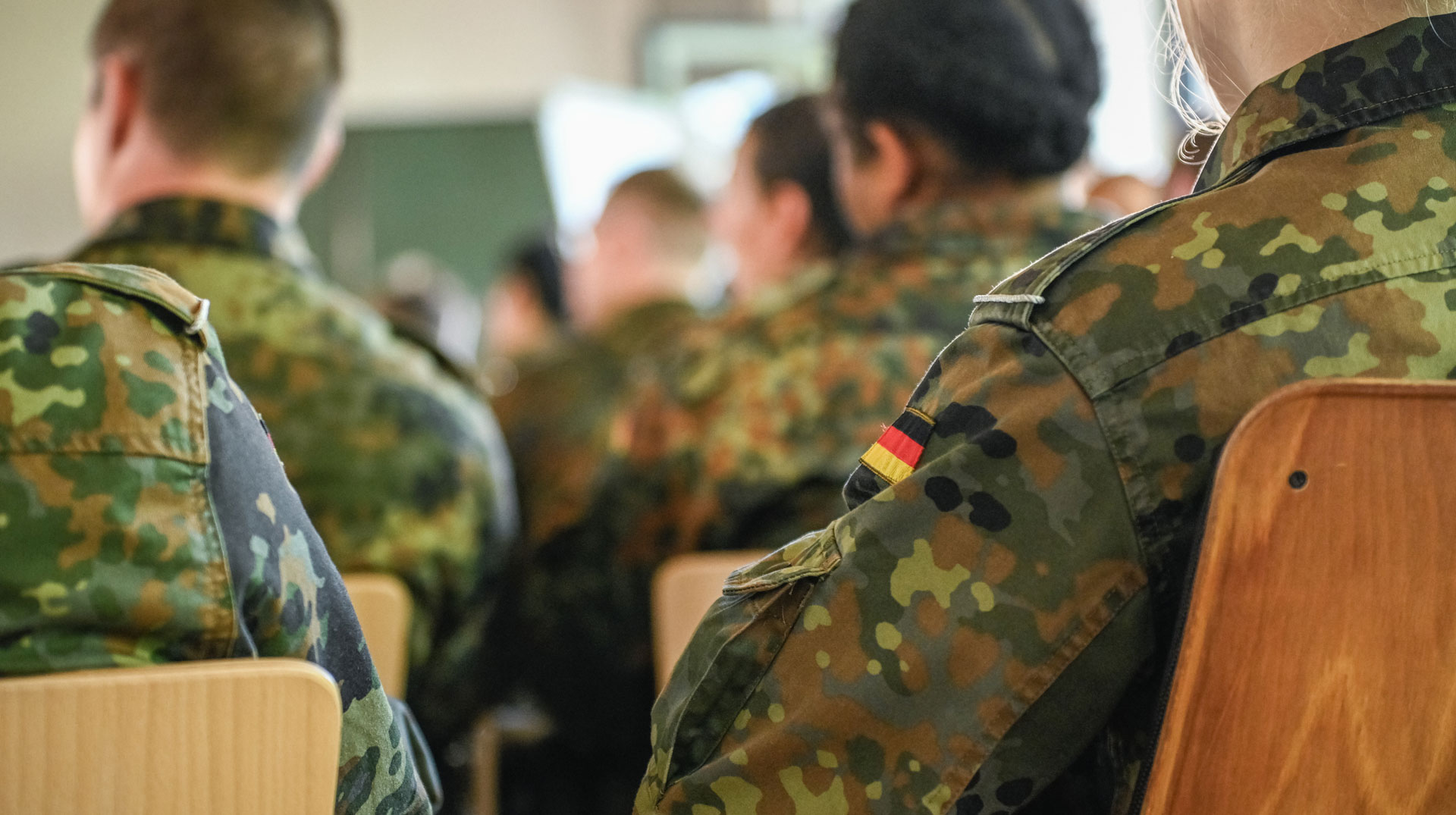 Rekruten sitzen in Reihen, eine Frau hat ihre Haare zu einem Knoten gebunden, am 11. August 2025 beim Lebenskundlichen Unterricht in Rennerod.