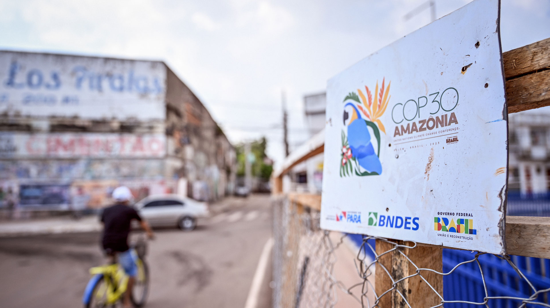 COP30 Amazonia (COP30 Amazonien) steht am 16. Oktober 2025 auf einem Schild an einer Straße in Belém (Brasilien), ein Fahrradfahrer fährt vorbei.