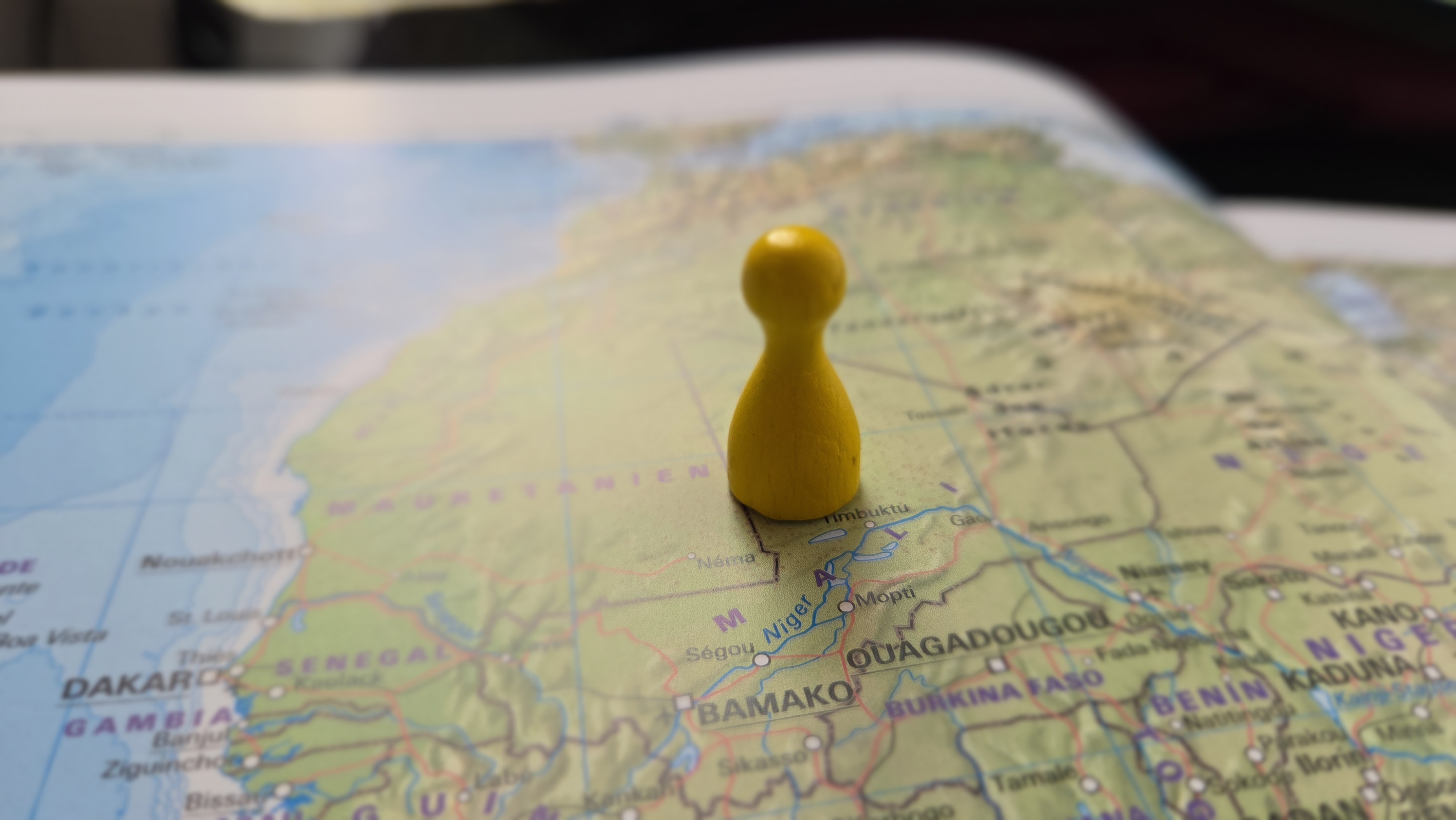 Eine Spielfigur steht auf einer Landkarte mit der Aufschrift "Mali"